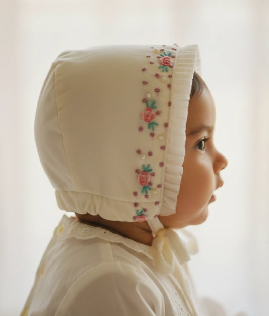 Handworked off-white baptism cap for babies featuring delicate embroidery and soft adjustable ties.
