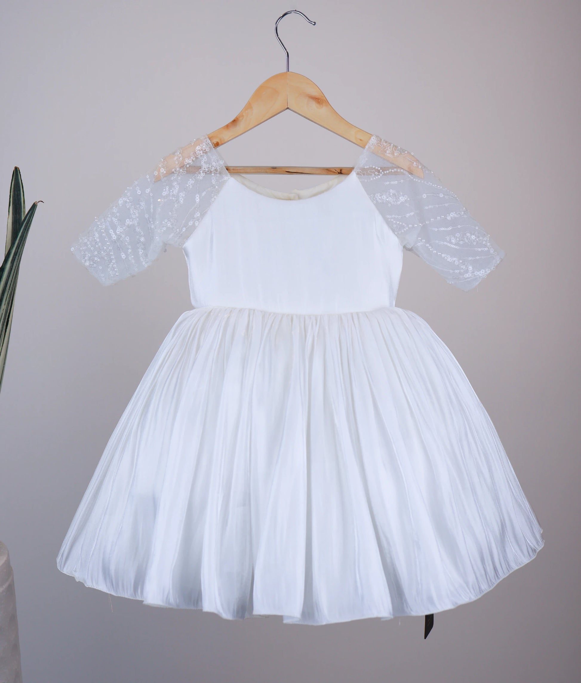 Front view of an off-white lacer organza flower girl dress for baby girls featuring sheer embellished medium sleeves and a flared skirt