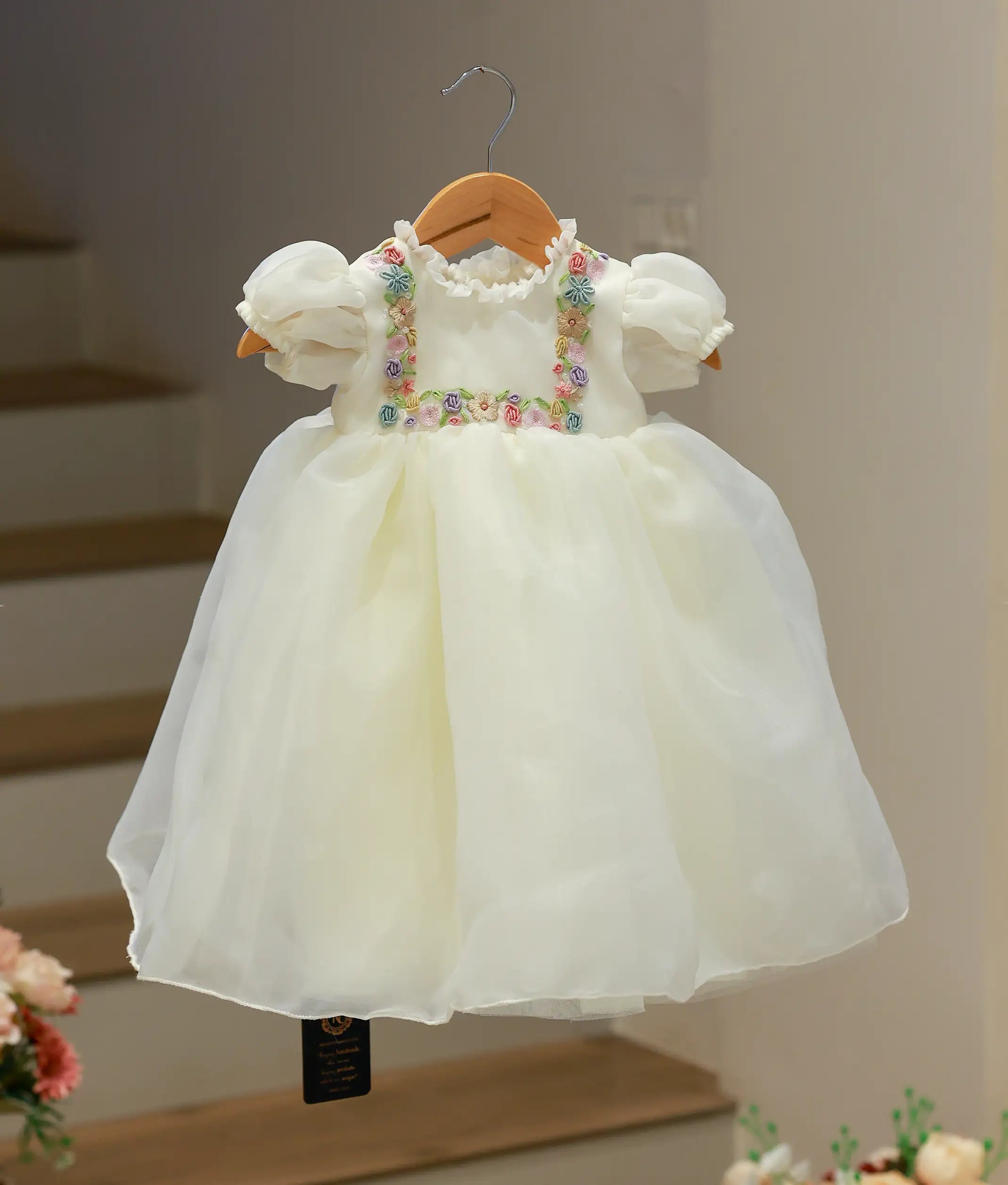 Full front view of an off-white baby girl baptism frock crafted from plain organza with delicate hand-worked embroidery on the bodice