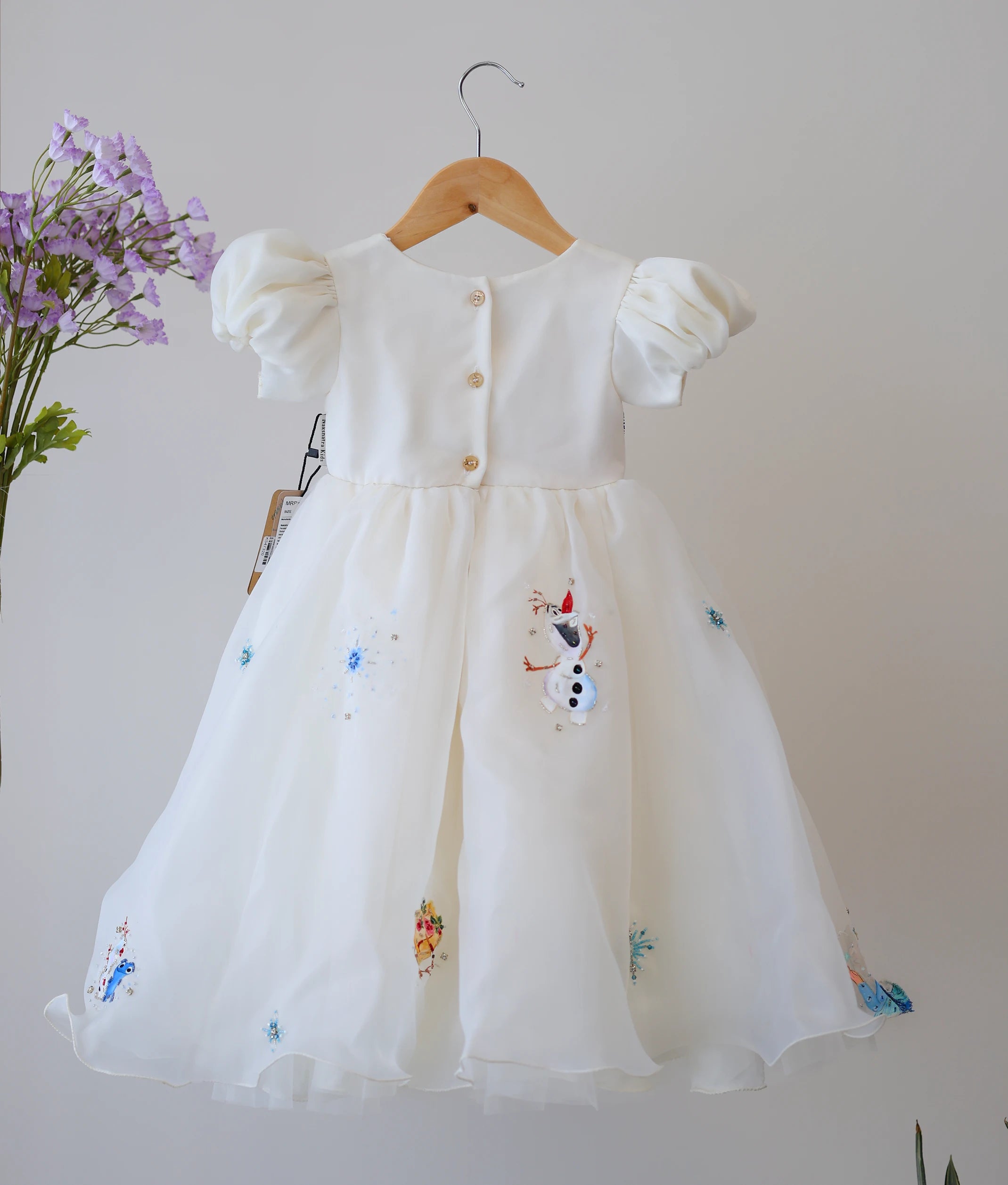 Back view of the off-white Disney princess theme dress showing the round neck and simple button closure