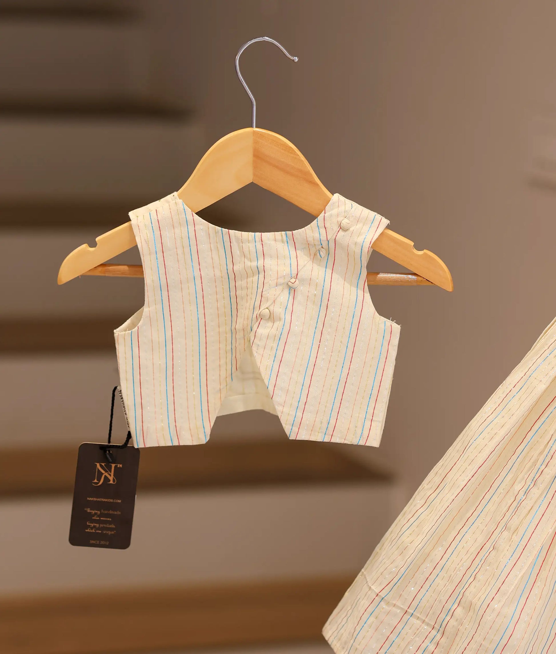 Back view of the off-white cotton skirt and top set showing the round neck and button closure on the top