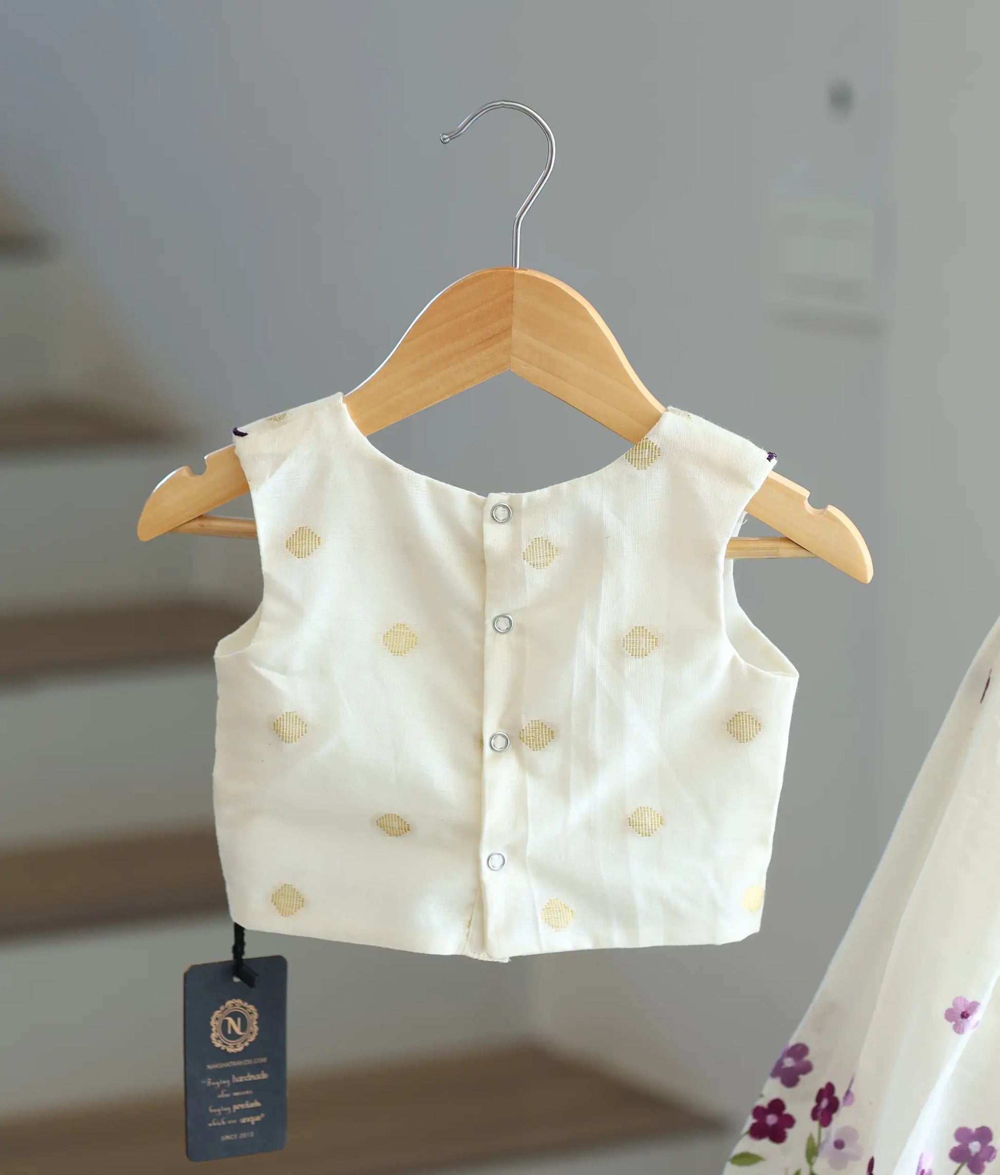 Back view of the off-white top showing the secure button closures.
