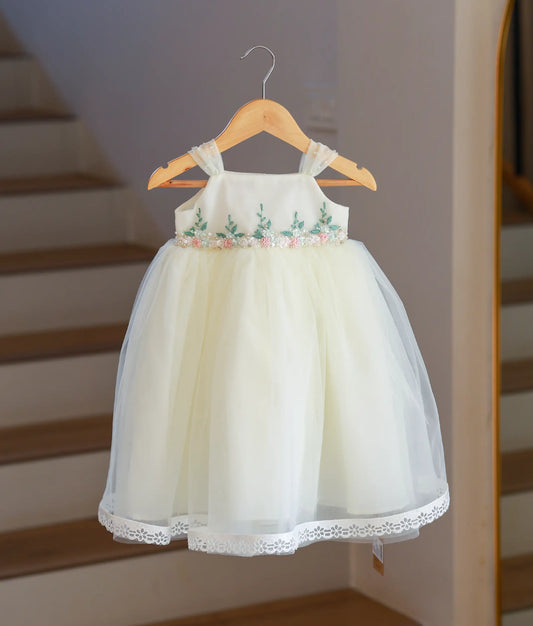 Front view of an off-white tulle baptism gown featuring a square neck and lace hem.