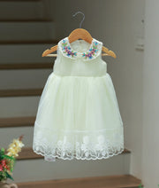 Full front view of an off-white tulle net baptism frock for baby girls featuring a hand-embroidered Peter Pan collar and a voluminous layered skirt.
