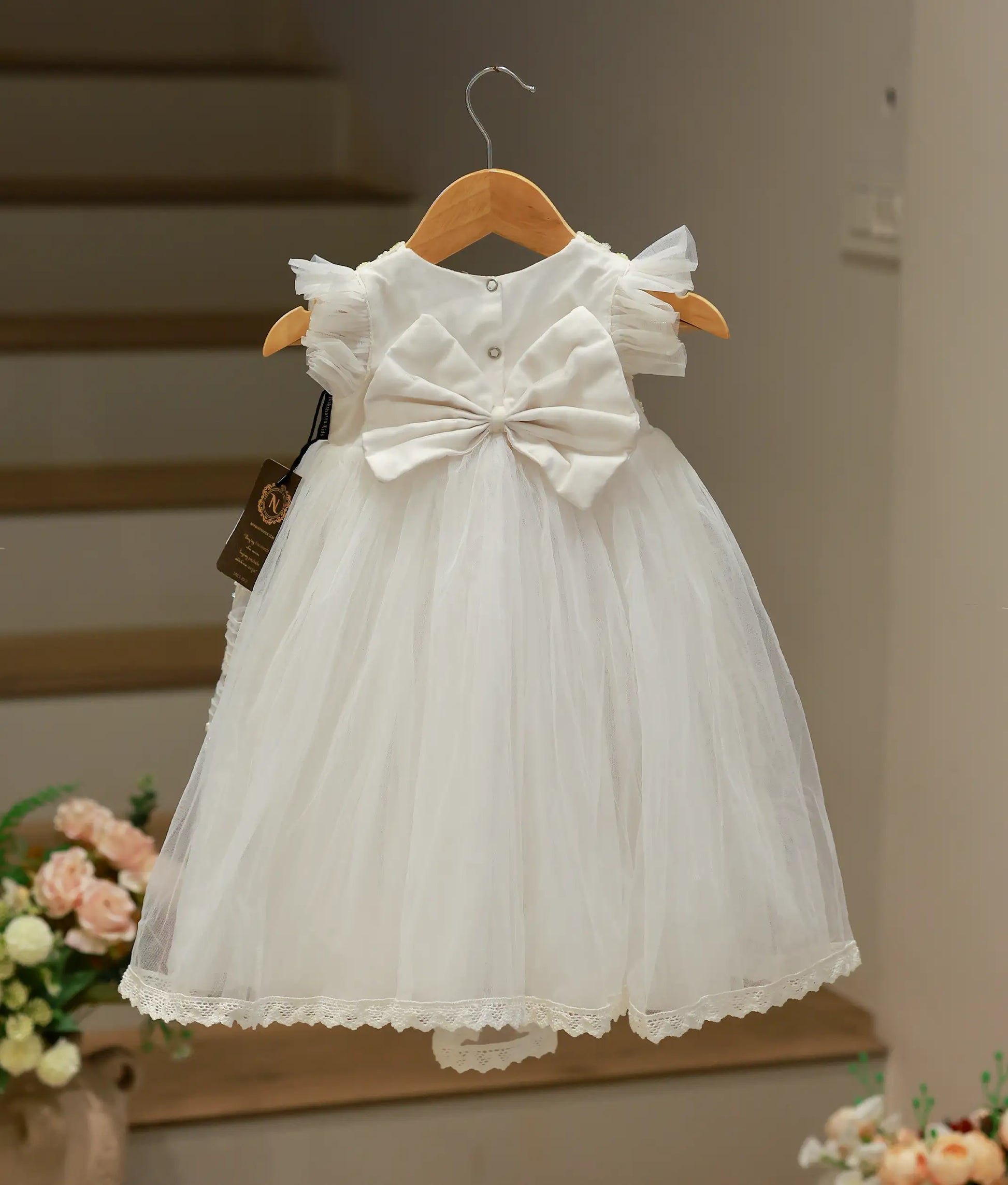 Back view of the off-white handworked baptism gown showing the elegant long silhouette and sophisticated back closure.