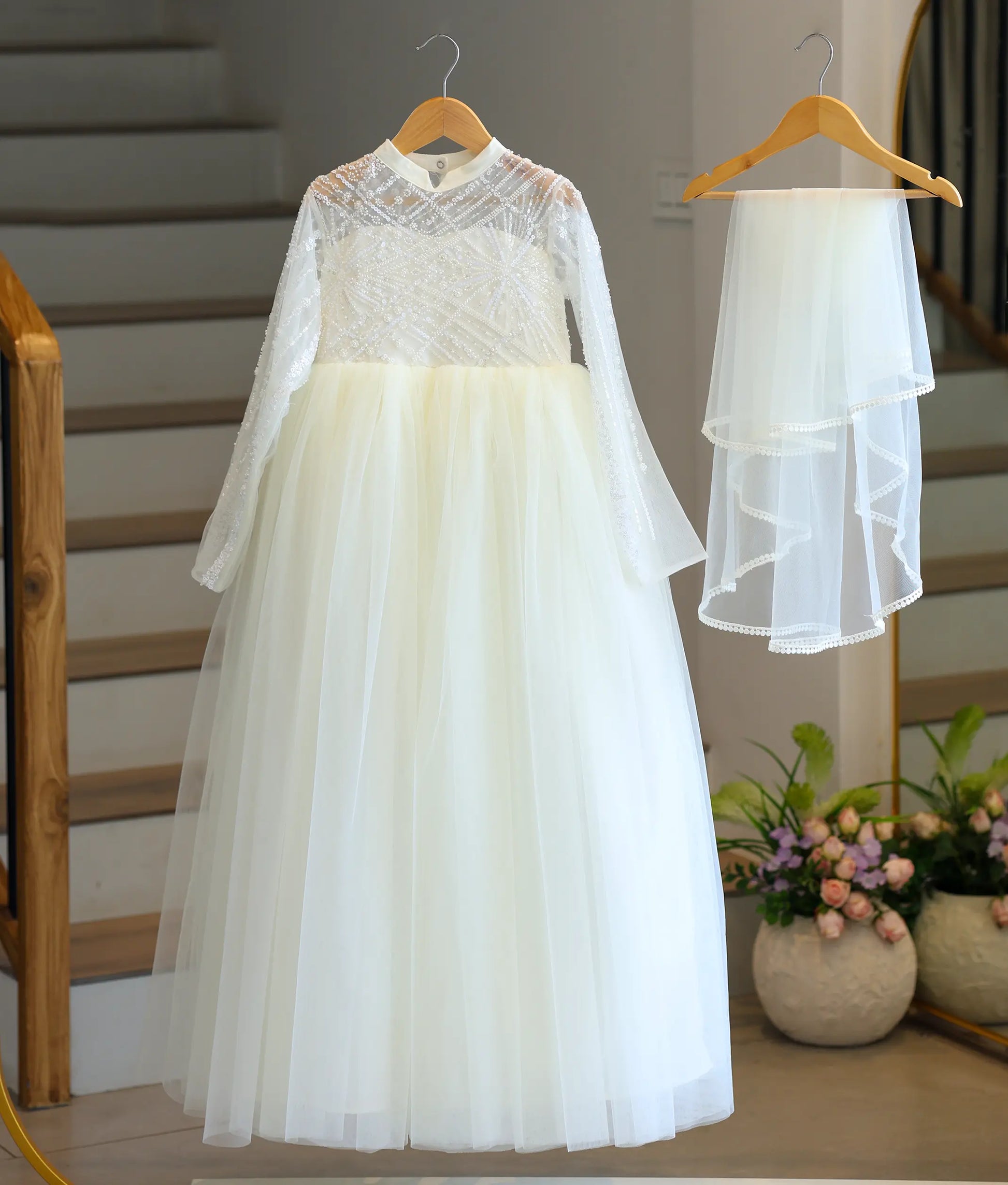 Full-length front view of the off-white tulle net Holy Communion dress with its matching veil, highlighting the flared floor-length bottom and the sequin work top.