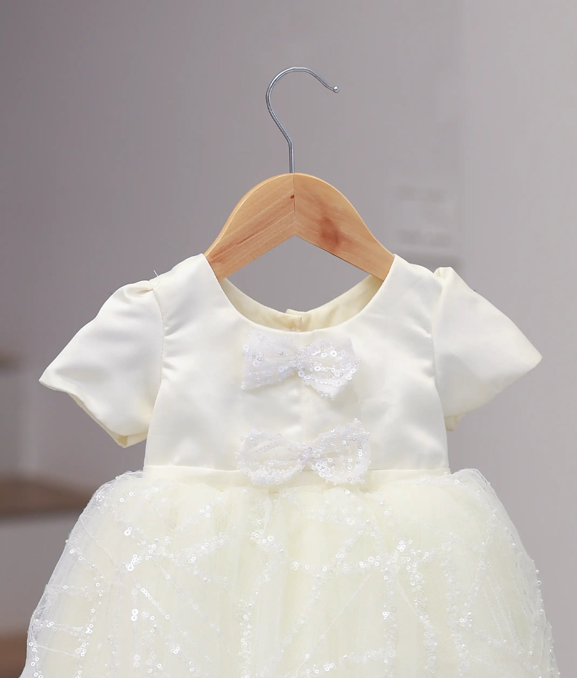 Close-up of the off-white frock yoke showing detailed hand embroidery and the highlight decorative bow