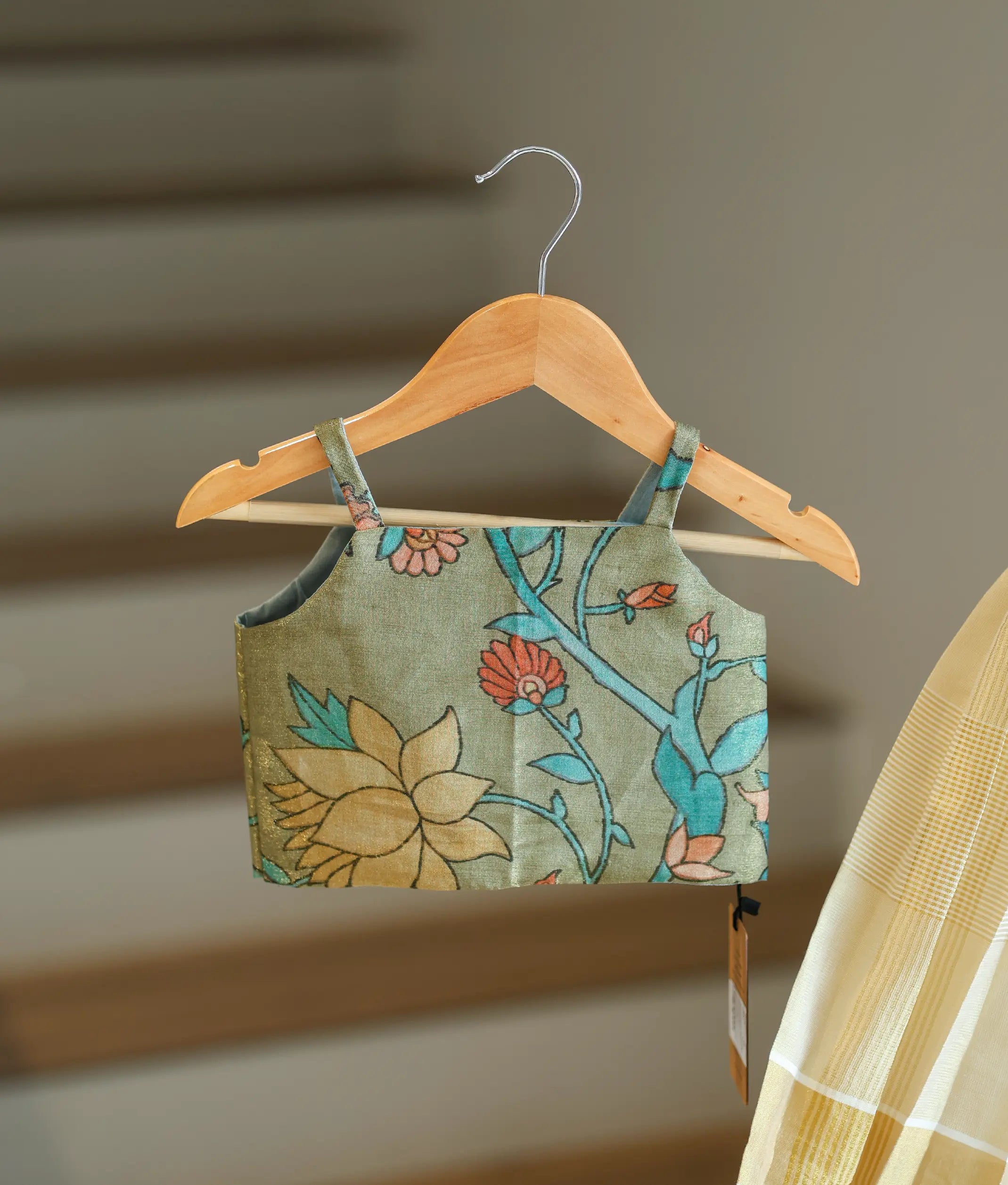 Close-up showing the colorful floral pattern on the green top.