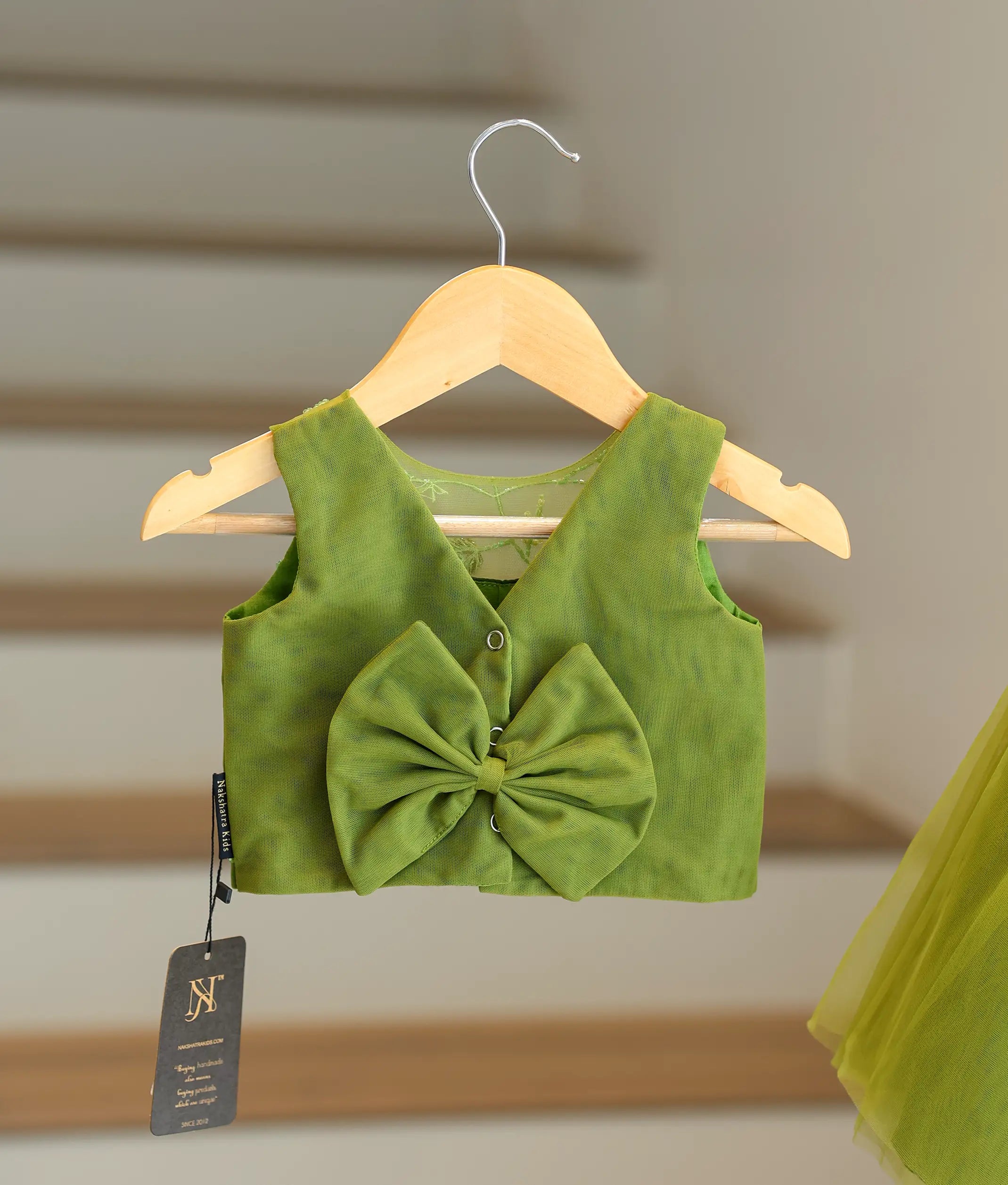Back view of the olive green set showing the V-neck, button closure, and decorative bow