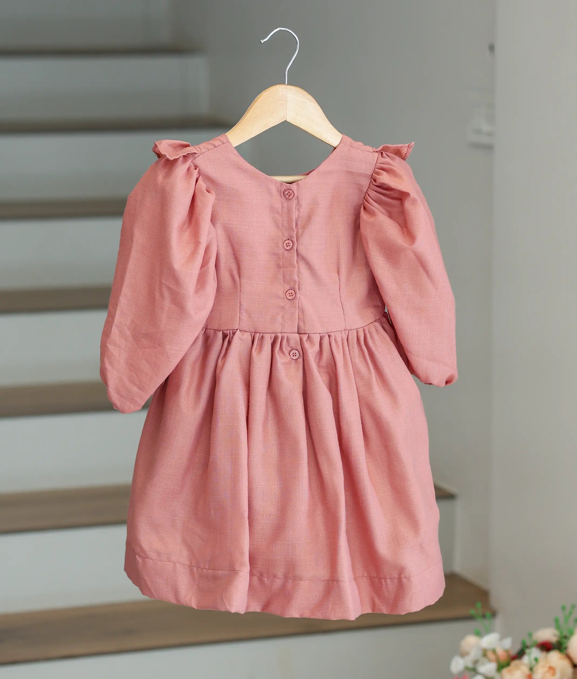 Back view of the onion pink cotton frock showing the button closure