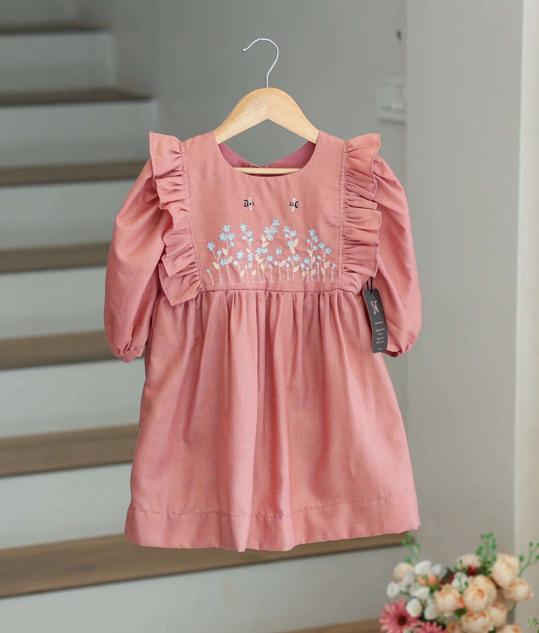 Front view of an onion pink cotton birthday frock for baby girls with floral handwork