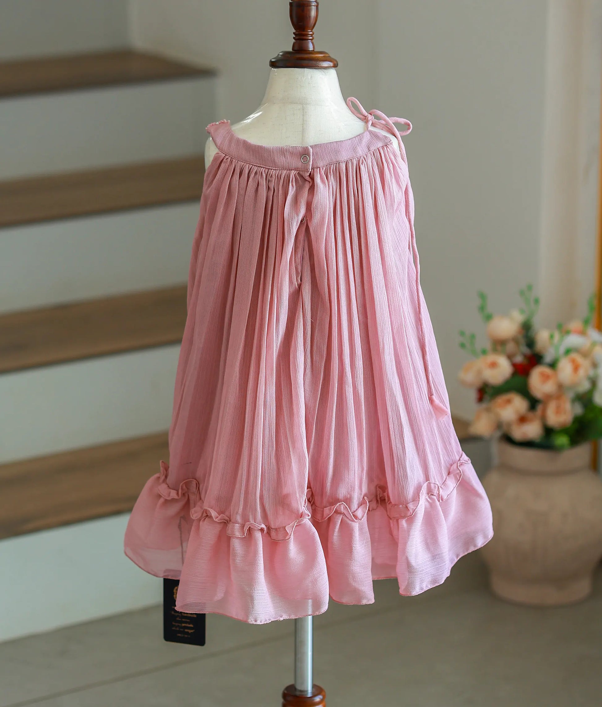 Back view of the onion-pink frock showing the shimmer georgette fabric and ruffled hemline.