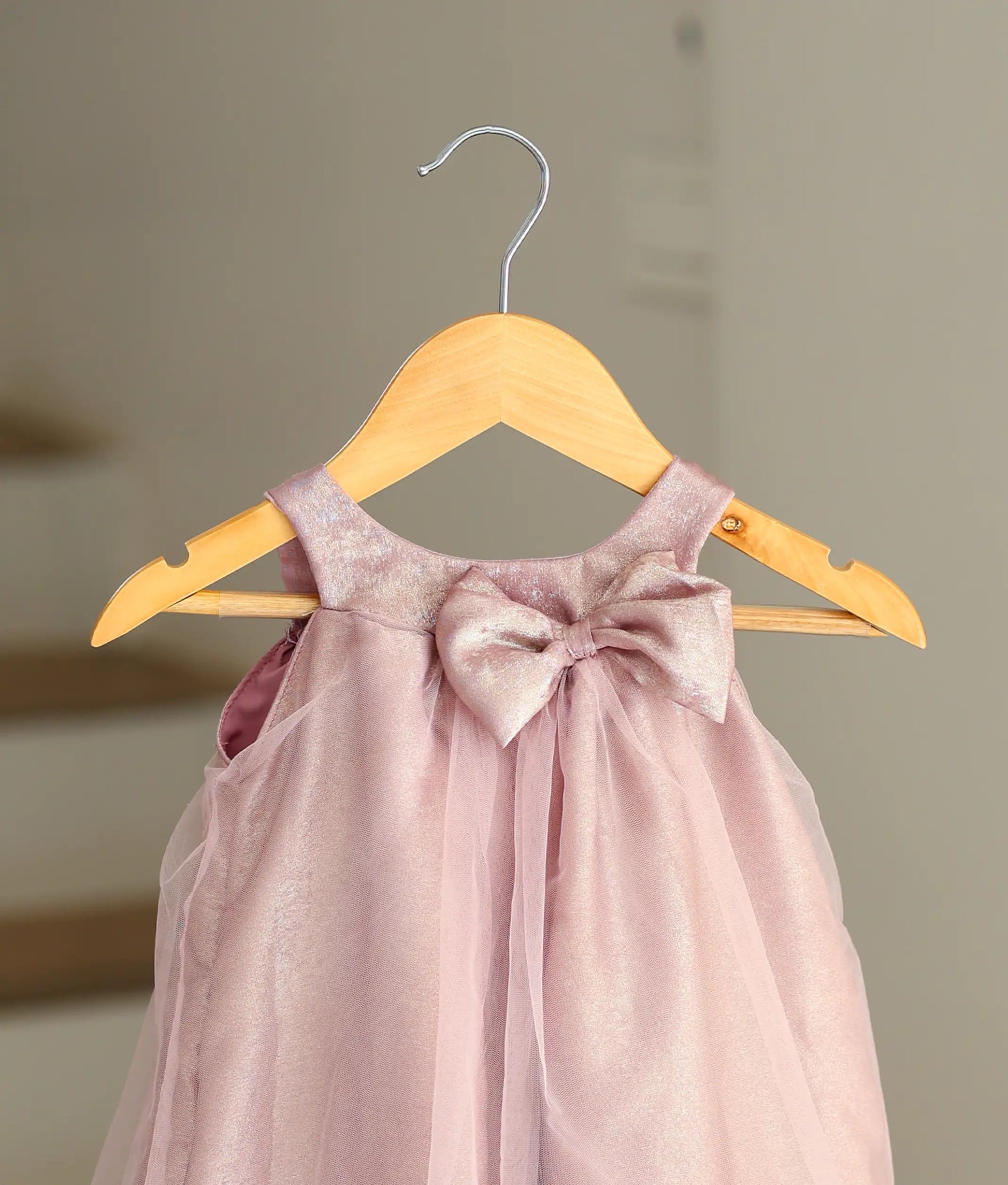 Close-up of the frock with a bow on the onion-pink birthday dress