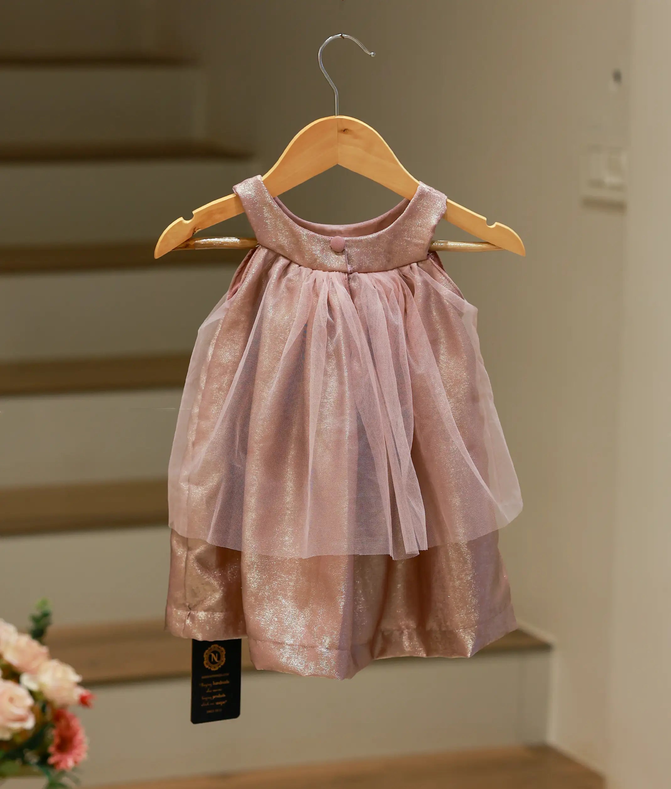 Back view of the onion pink shimmering halter neck frock showing the button closure.