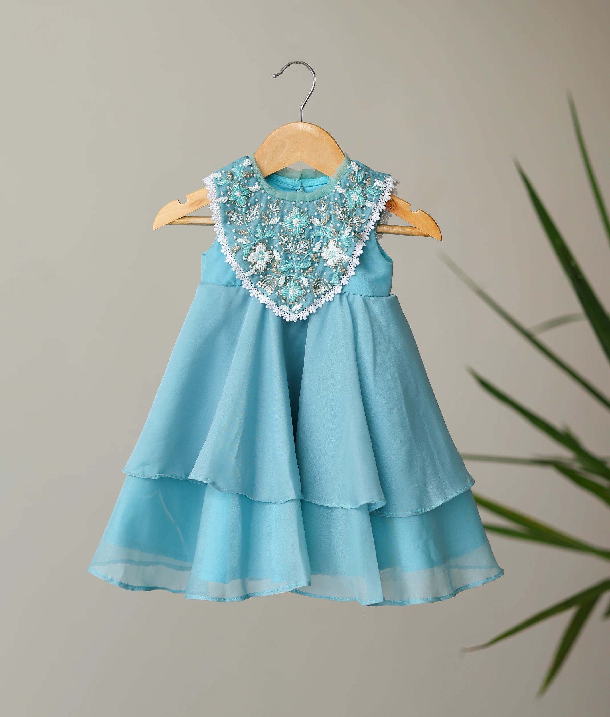 Pastel blue butter organza birthday frock with a hand-beaded floral yoke and tiered step skirt