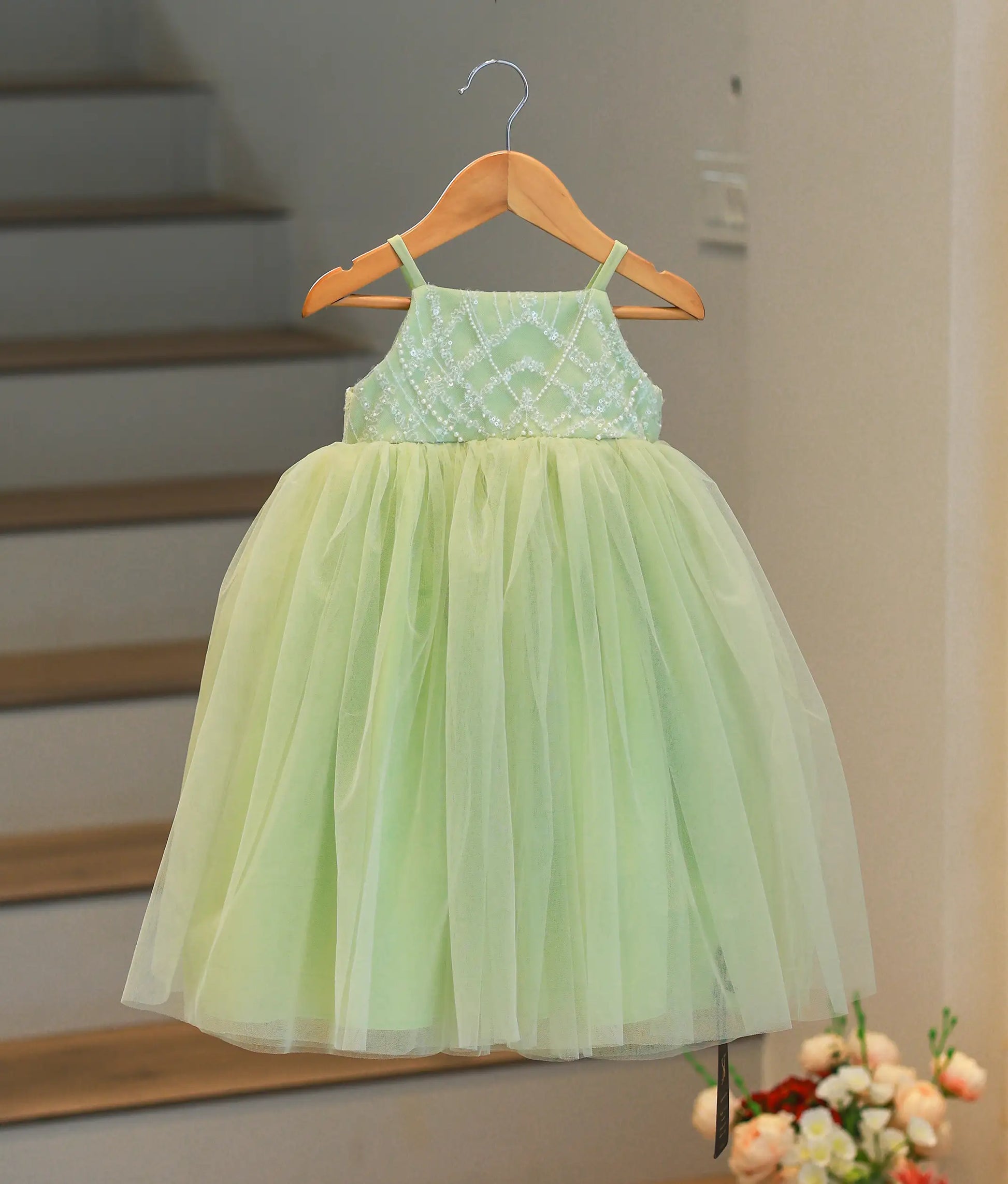 Front view of a pastel green birthday gown for girls with a handworked diamond pattern top and layered tulle bottom.