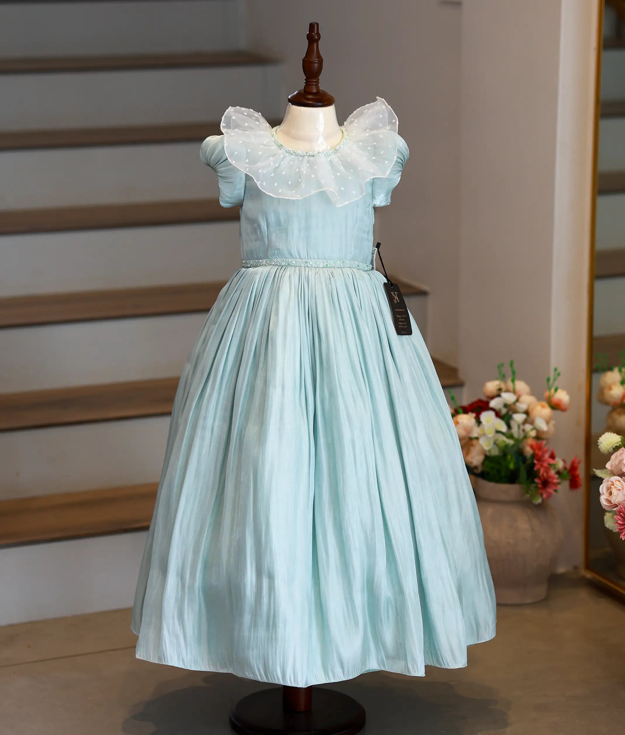 Front view of a pastel green laser organza handworked birthday gown for baby girls featuring a full-length flared skirt and puff sleeves
