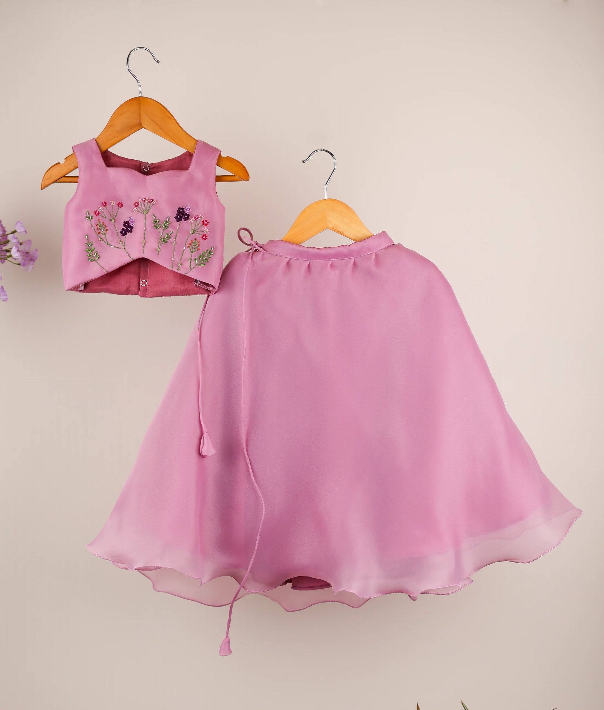 Front view of the pastel lavender organza lehenga set for girls featuring intricate floral handwork on a square-neck top