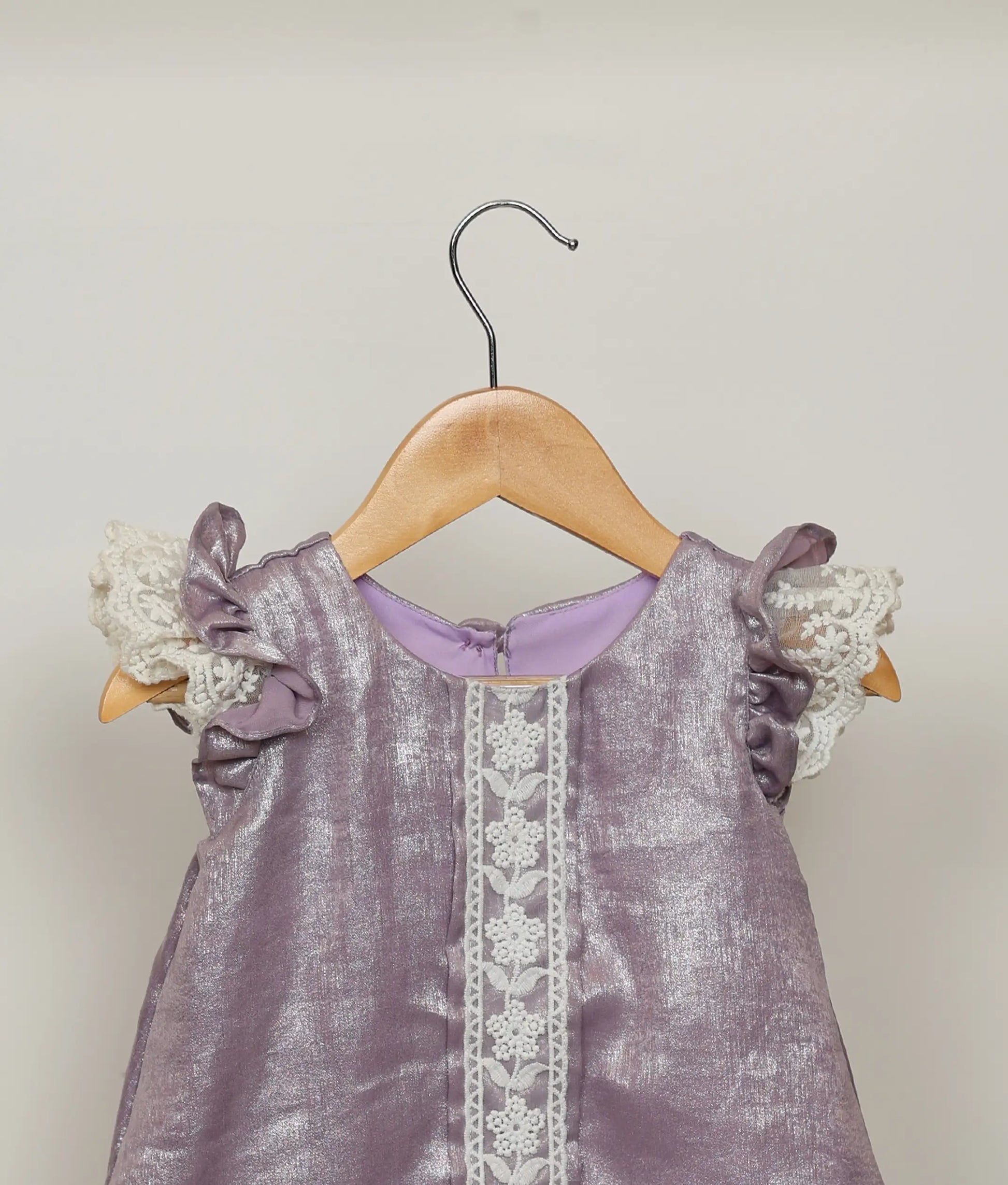Close view of an pastel lavender Aline frock with lace detailing.