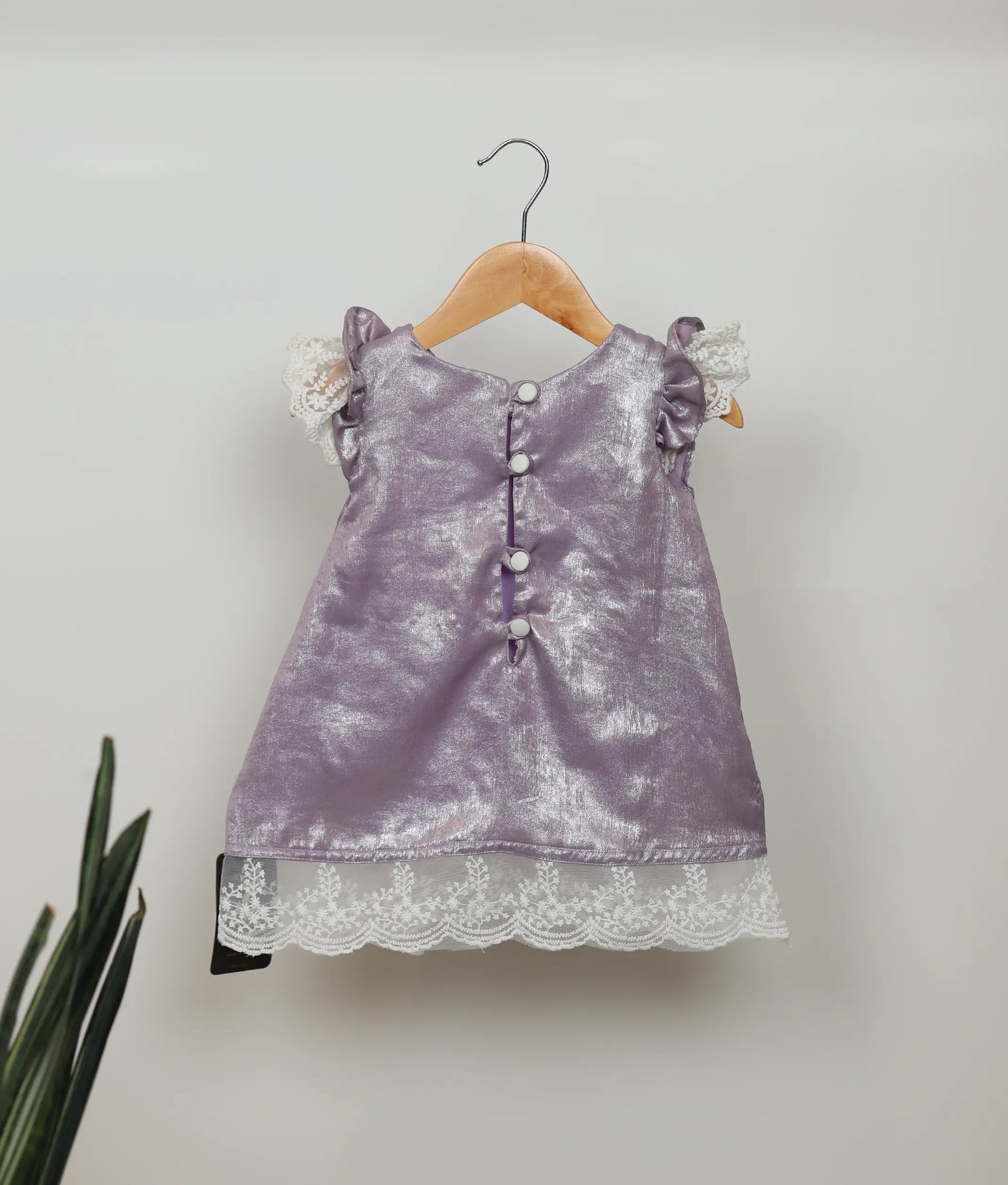 Back view of an pastel lavender A-line frock with lace detailing.