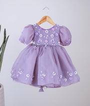 Front view of a pastel lavender organza girl's birthday dress with floral embroidery, beads, and balloon sleeves