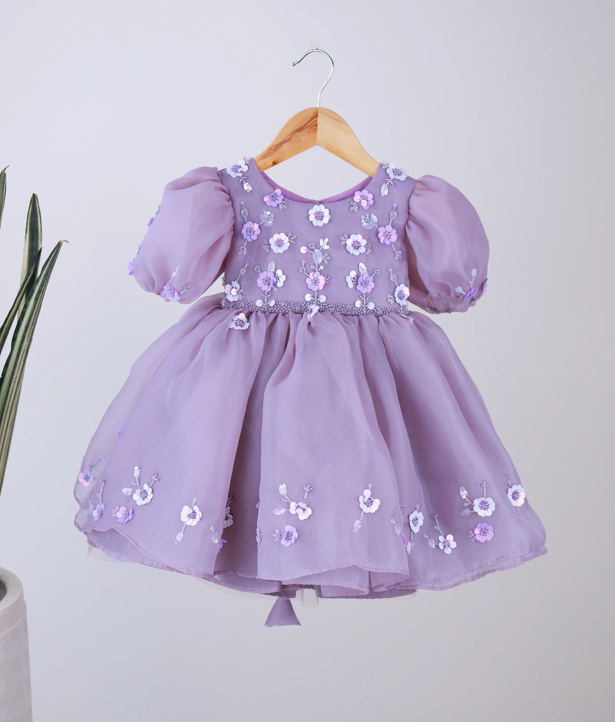 Front view of a pastel lavender organza girl's birthday dress with floral embroidery, beads, and balloon sleeves