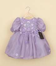 Front view of a pastel lavender organza girl's birthday frock with floral embroidery, beads, and balloon sleeves