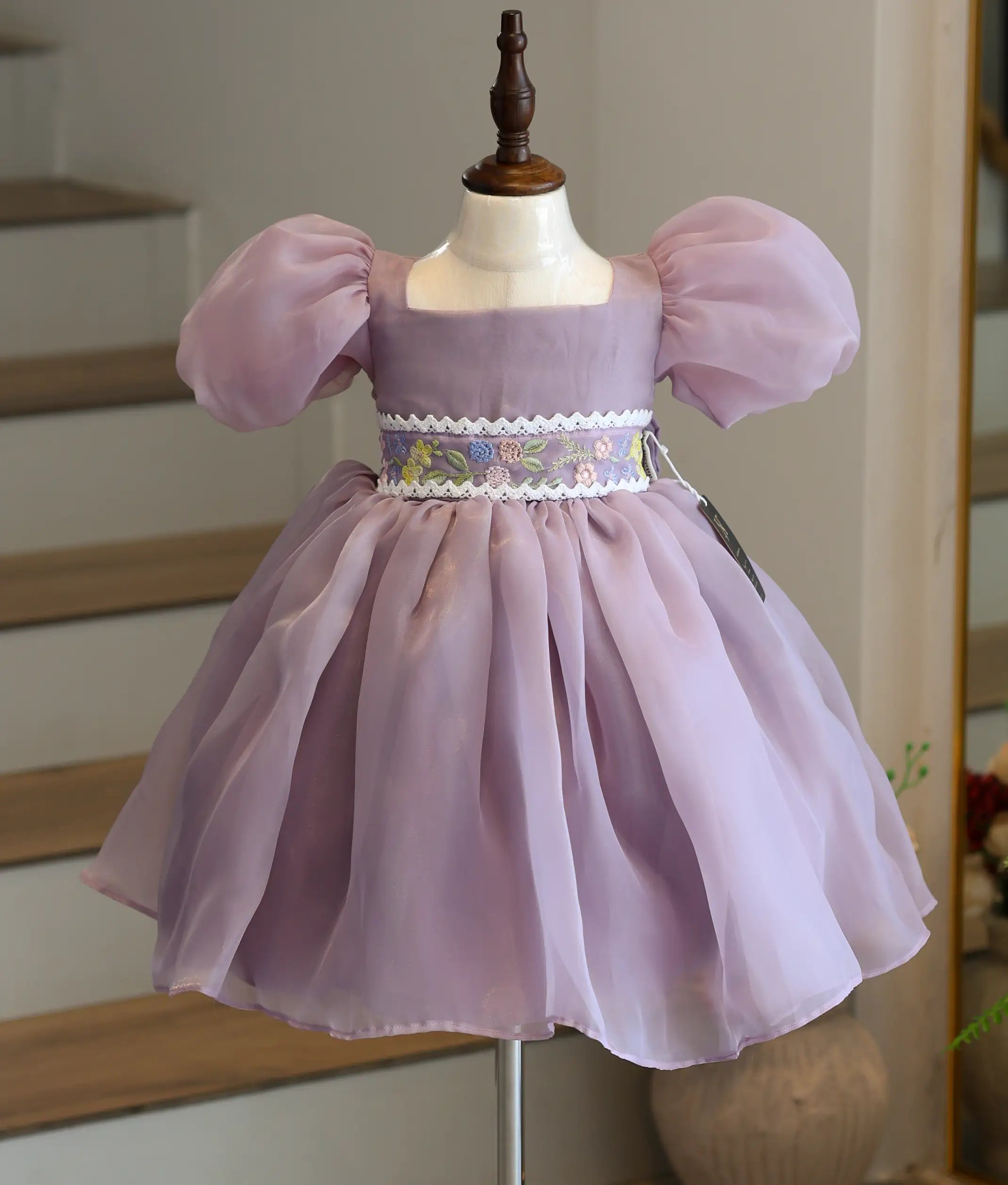 Front view of a pastel lavender premium organza birthday frock for baby girls with puff sleeves and embroidered belt