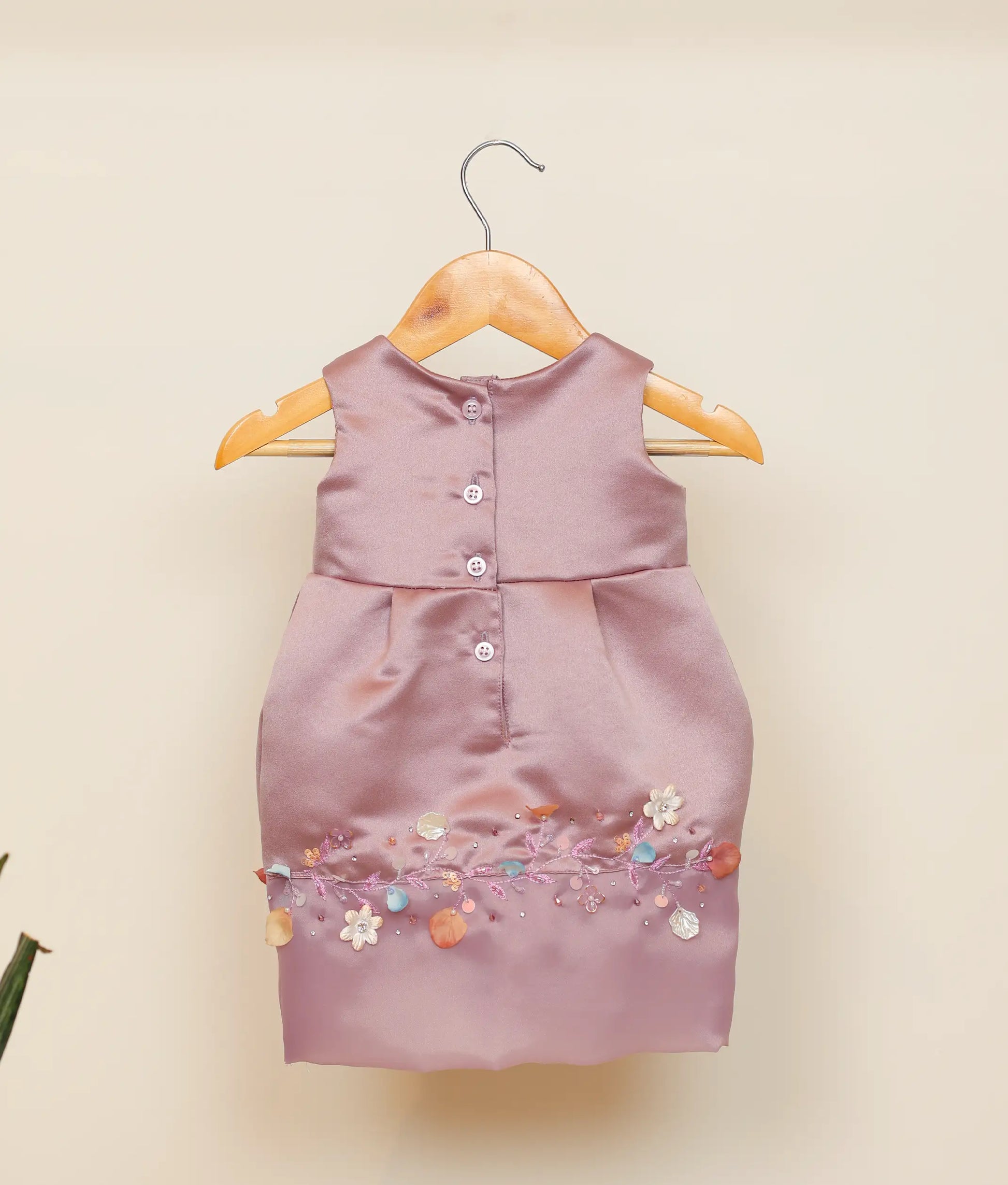 Back view of pastel lavender satin fish-cut frock showing the round neckline with button closure and the smooth flow of the below-knee skirt