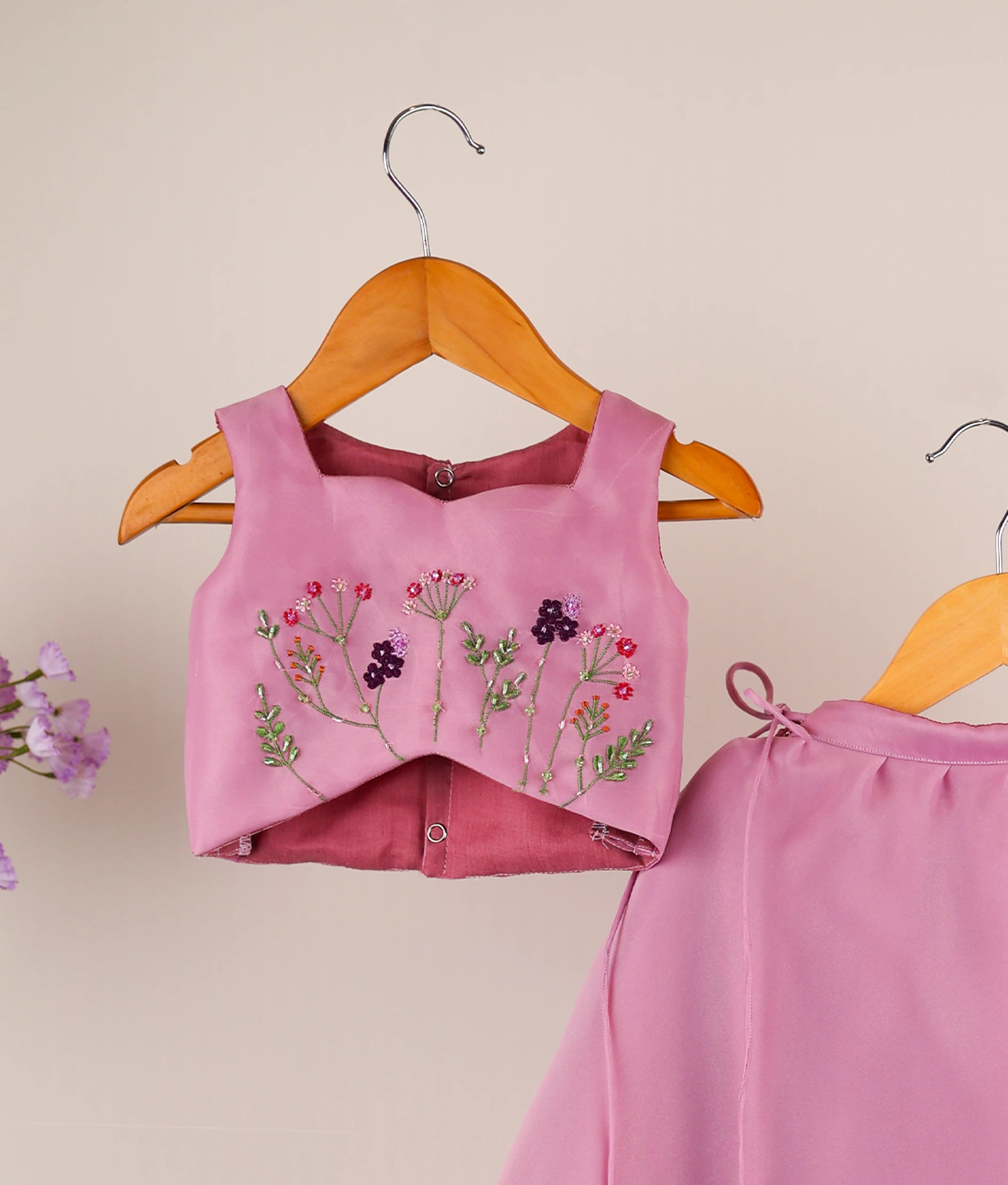 Close-up of the detailed pink, green, and purple floral handwork on the lavender organza short top