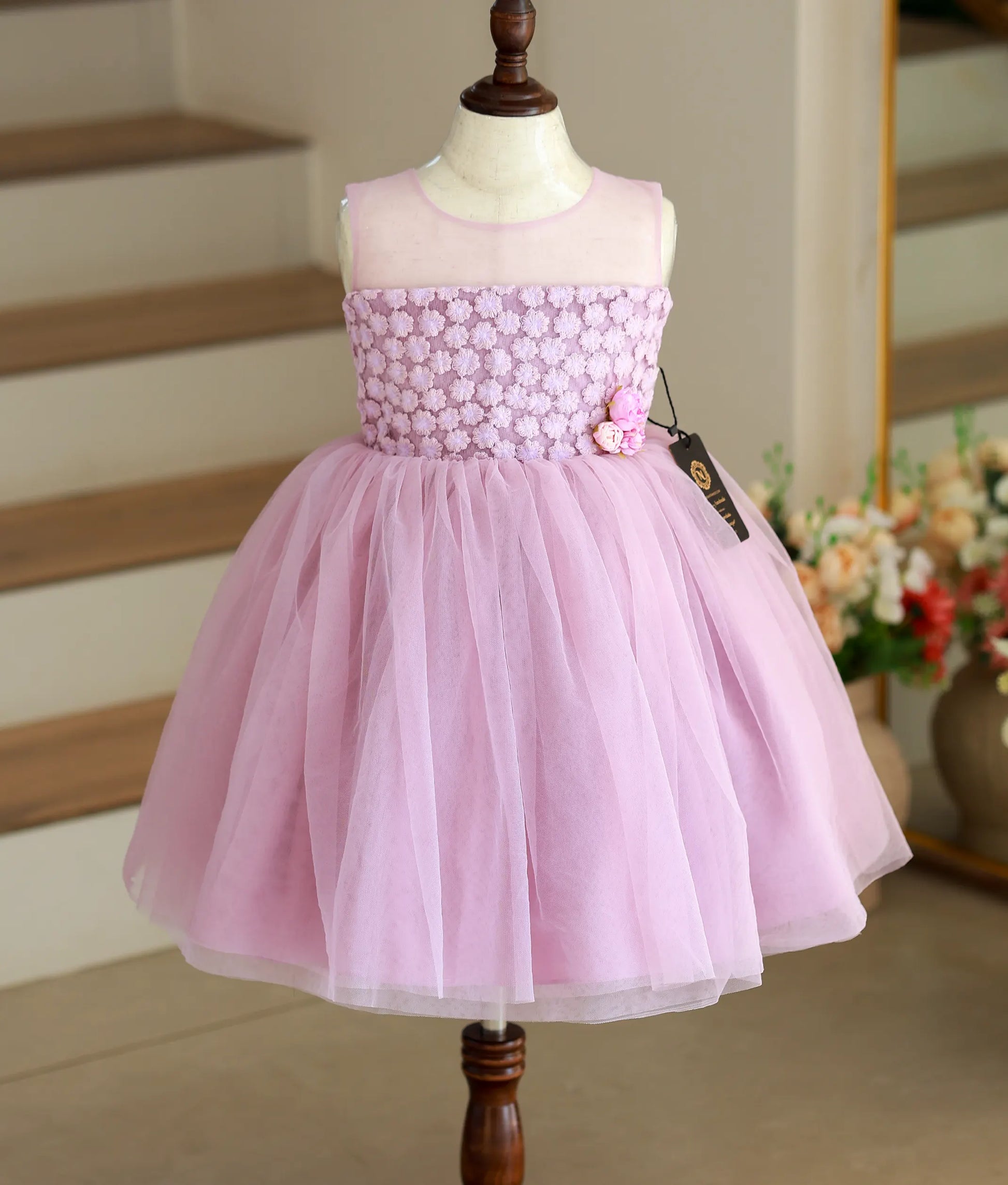 Front view of a pastel lavender frock for girls featuring a transparent upper bodice and intricate floral work material.