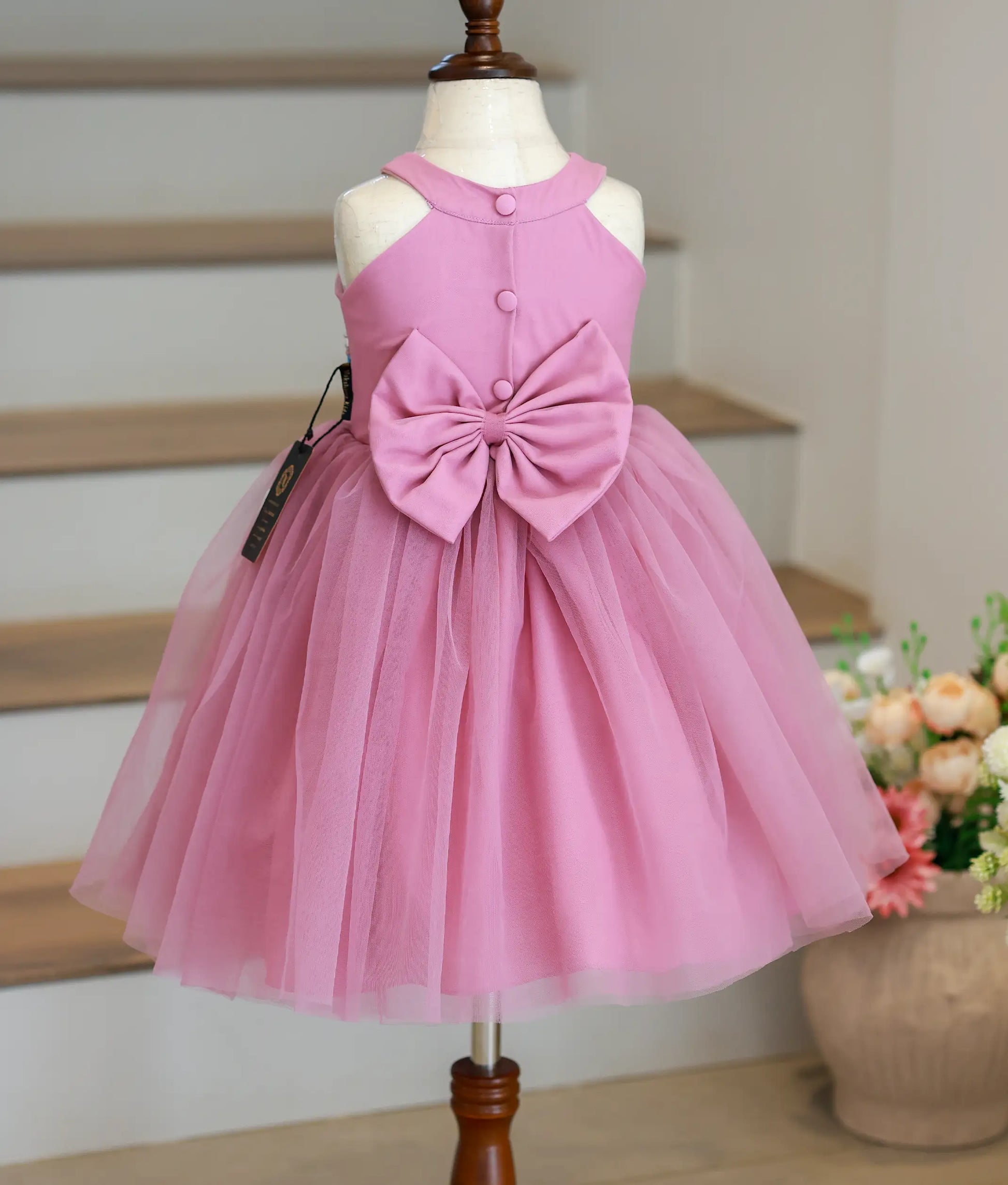Back view of the pastel lavender birthday frock highlighting the elegant halter back and the large statement tulle bow.