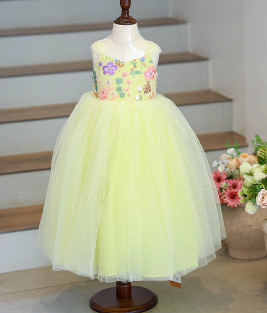 Full front view of a pastel yellow full-length birthday gown for girls featuring a floral embroidered yoke and voluminous tulle skirt.