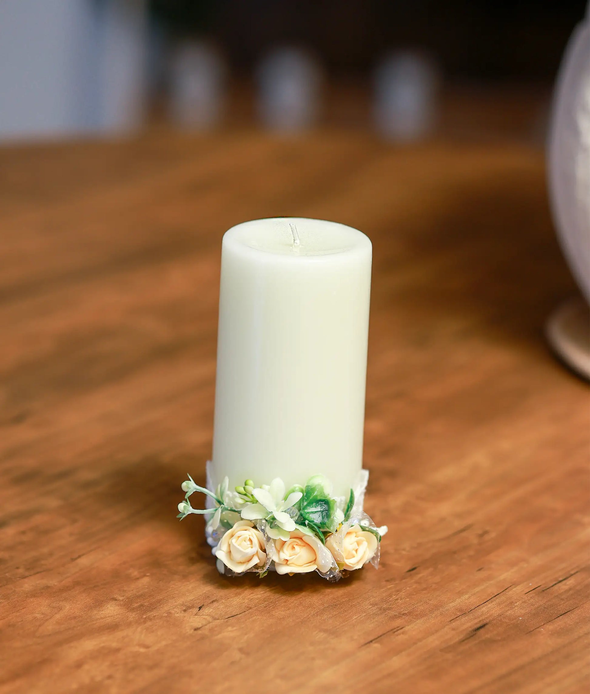 Close-up of the handcrafted peach roses, pearls, and delicate beadwork on the decorative baptism candle