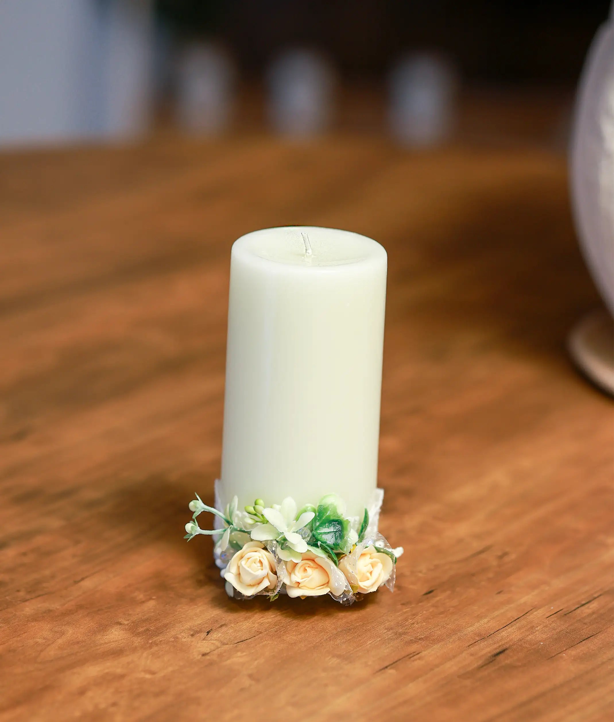 Close-up of the handcrafted peach roses, pearls, and delicate beadwork on the decorative baptism candle
