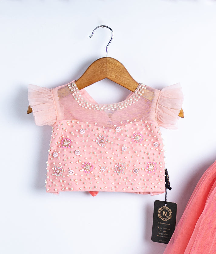 Close-up of peach lace top for baby and toddler dress outfit