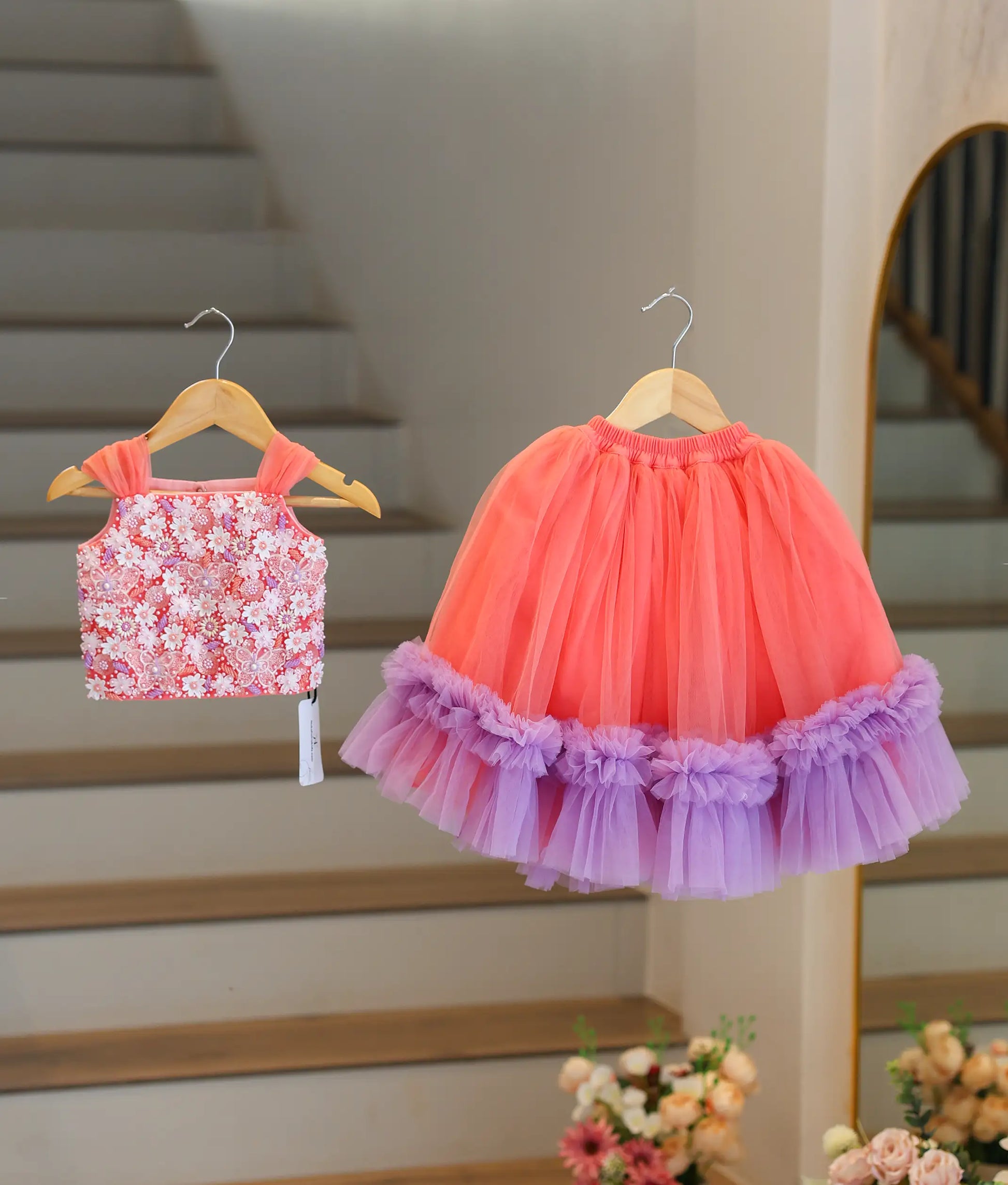 Front view of a peach and lavender handworked crop top and full-length layered skirt for baby girls