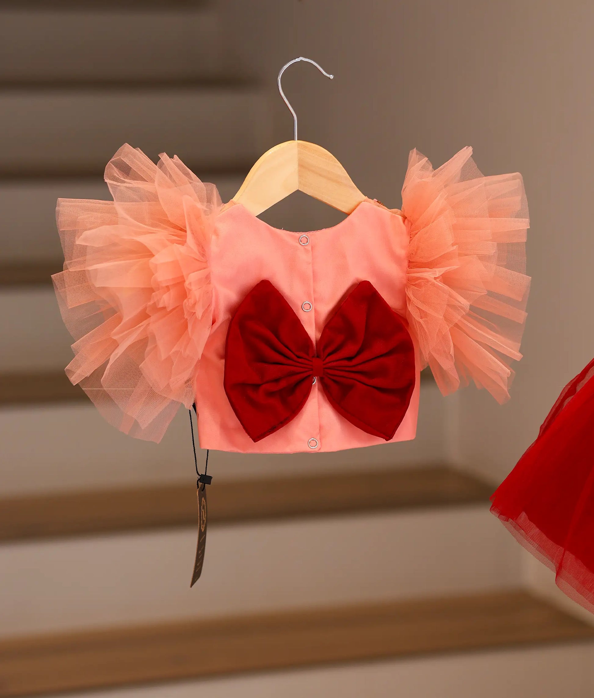 Back view of the peach and maroon set showing the round neck, button closure, and decorative bow