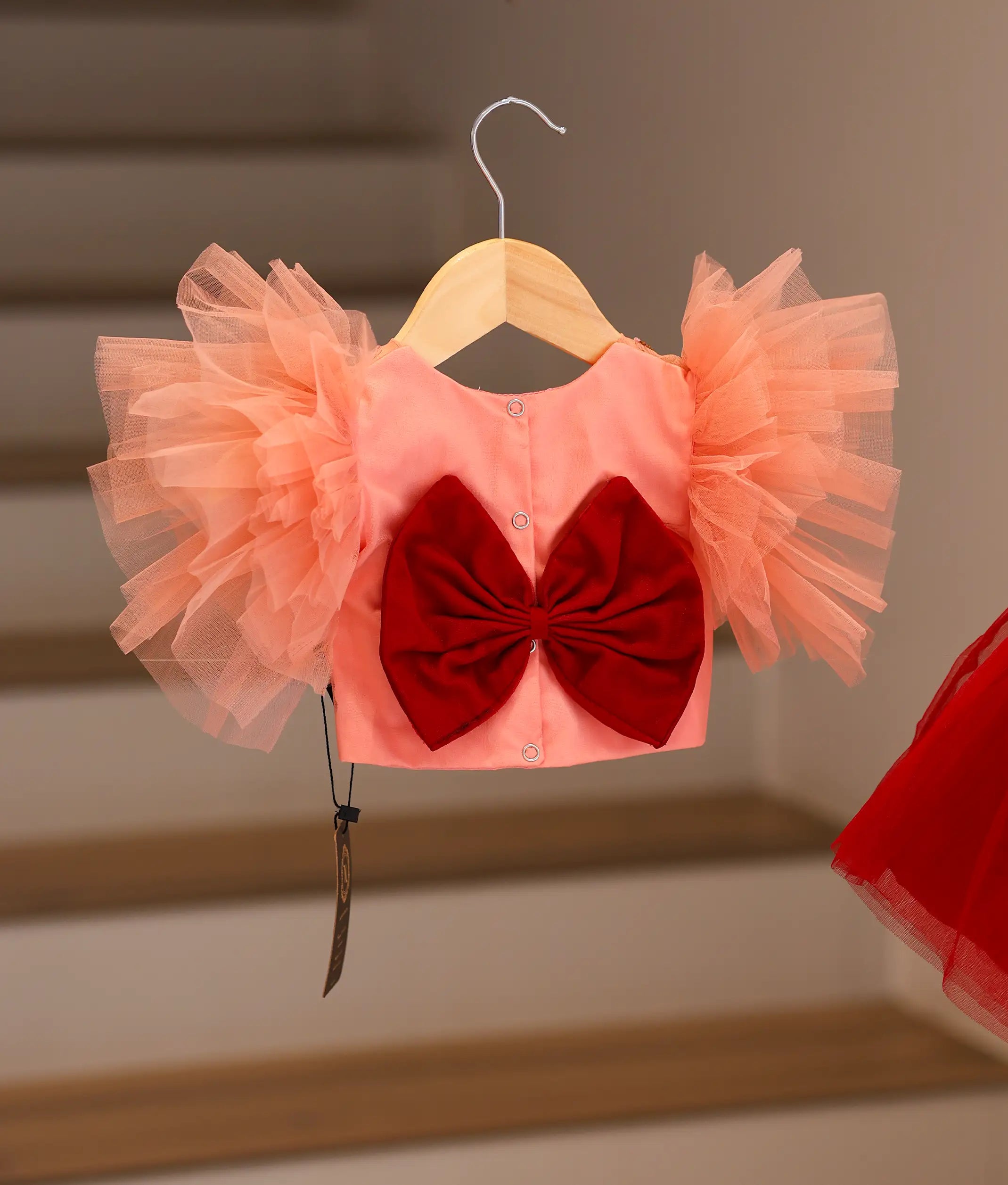 Back view of the peach and maroon set showing the round neck, button closure, and decorative bow