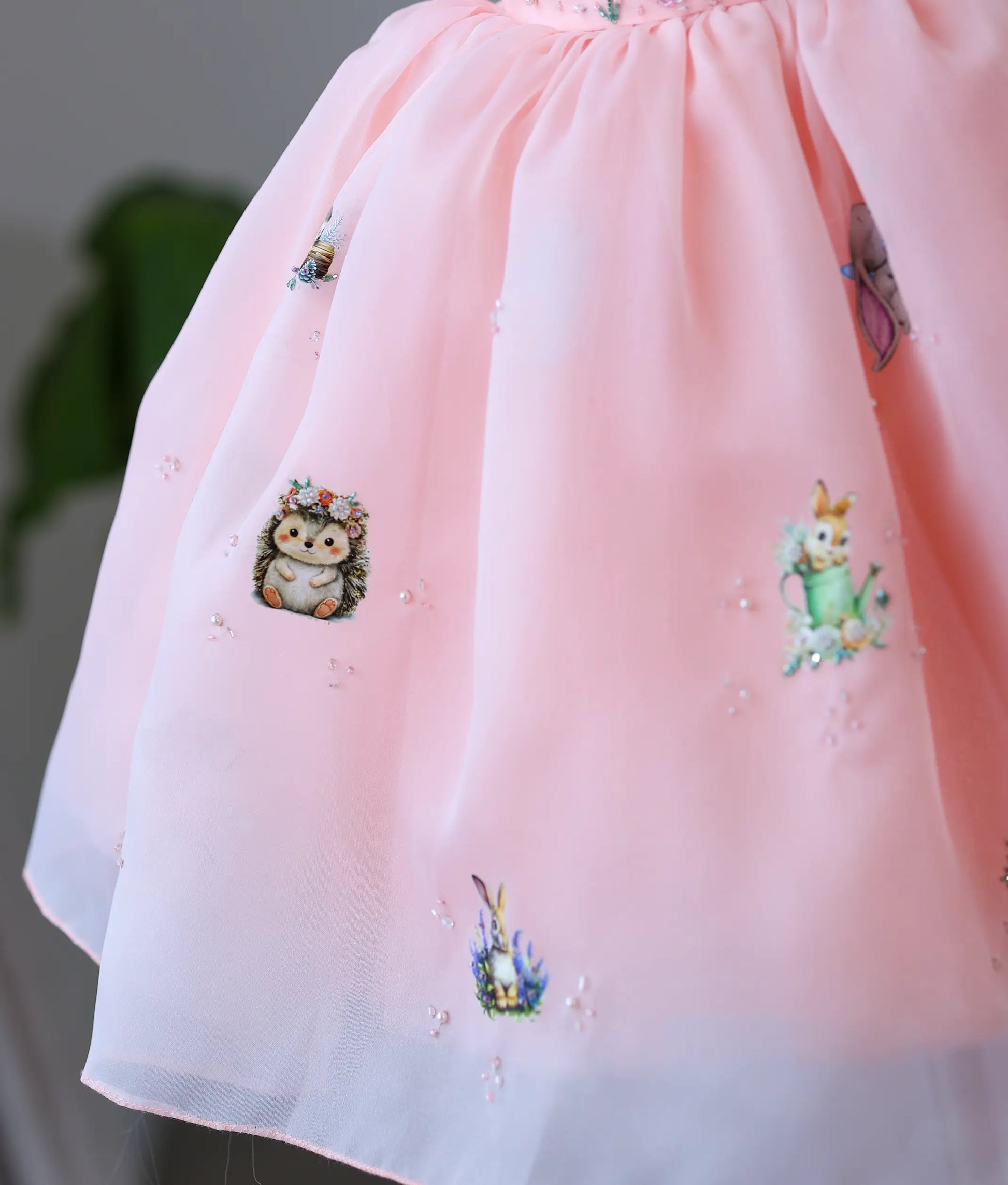 Detailed view of organza flared skirt with printed woodland animals and subtle handworked beads.