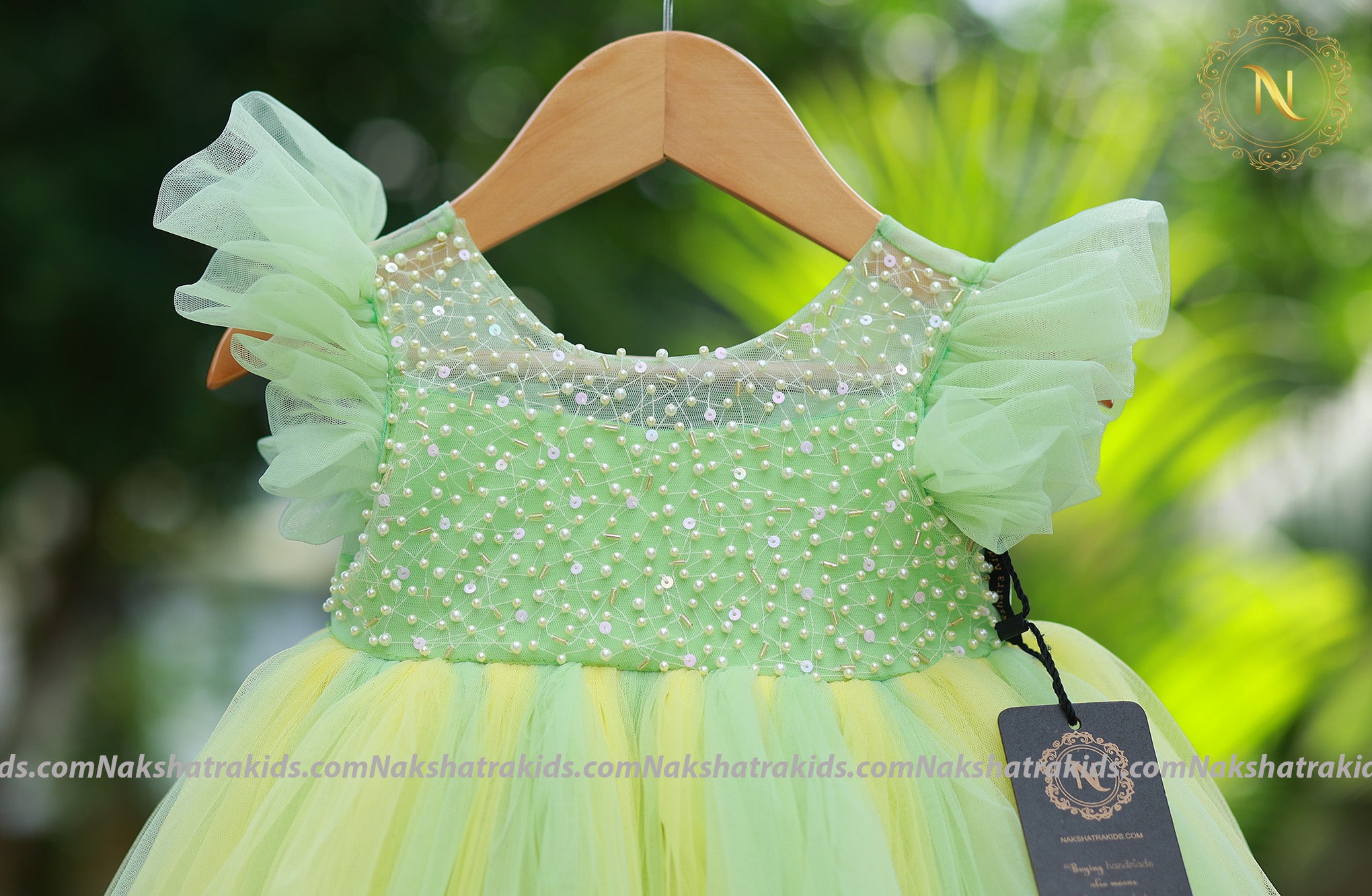Close-up of the intricate pearl-like bead embellishments on the bodice and the ruffled tulle net sleeves.