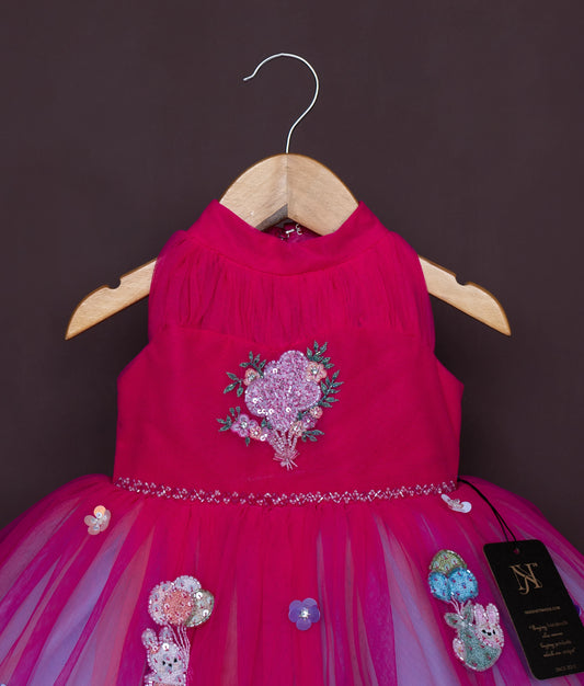 Side angle of pink baby girl dress featuring cartoon print and flared skirt