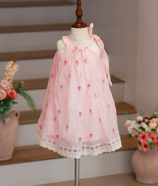 Full front view of a pink Chanderi cotton A-line party frock for girls featuring floral embroidery and a shoulder tie.