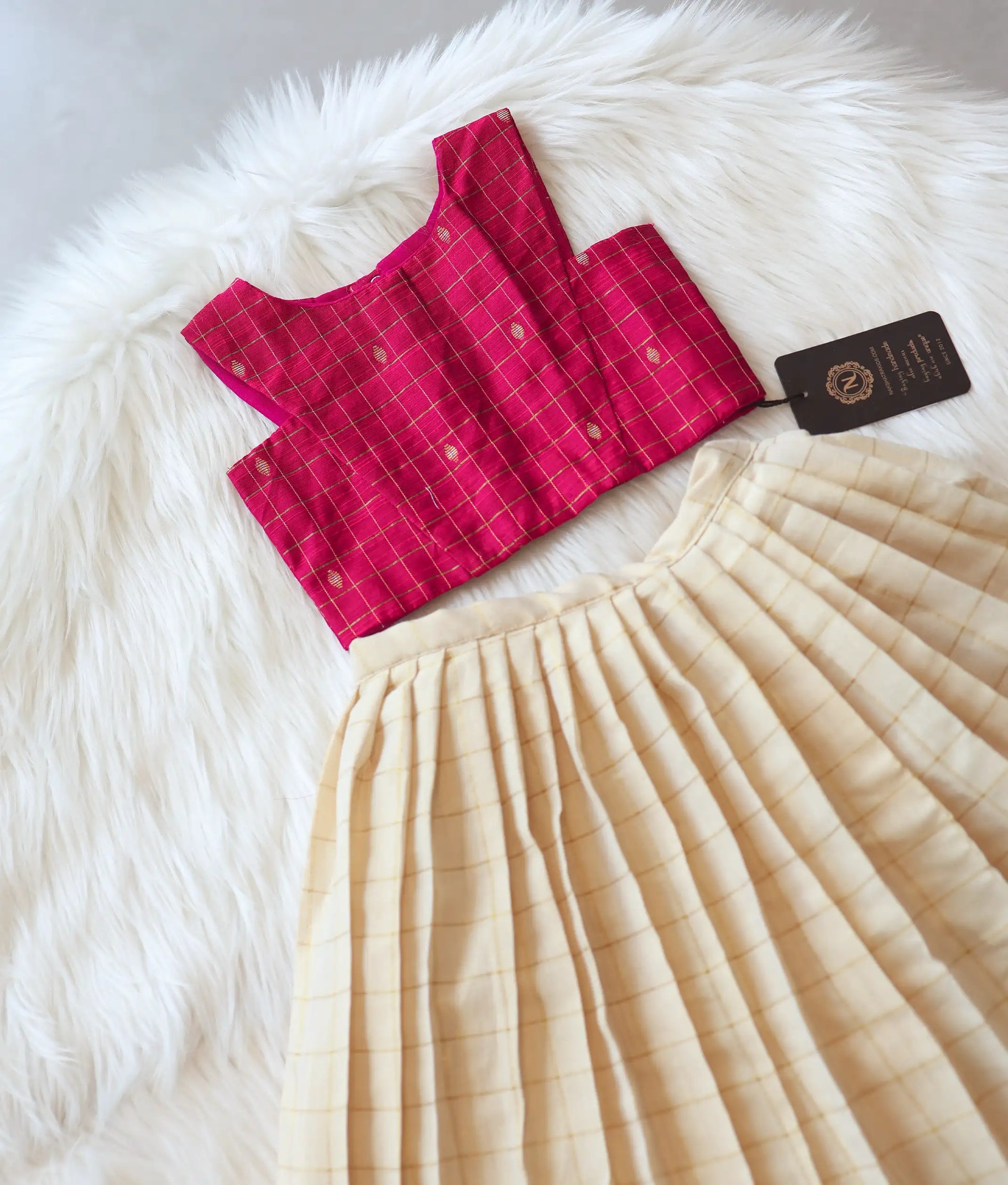 Close-up showing the gold checked pattern on the pink top.