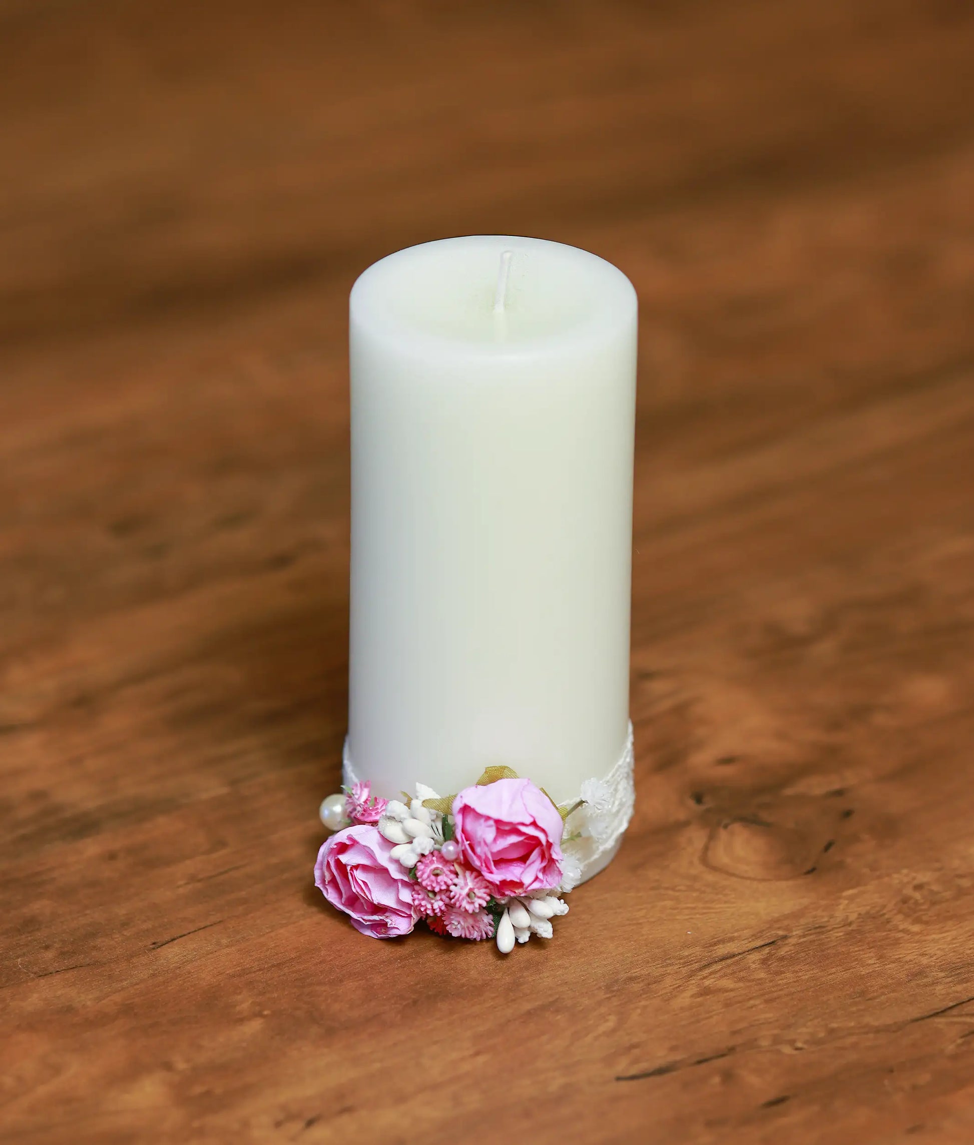 Close-up of the handcrafted pink roses, shimmering pearls, and intricate beadwork on the baptism candle