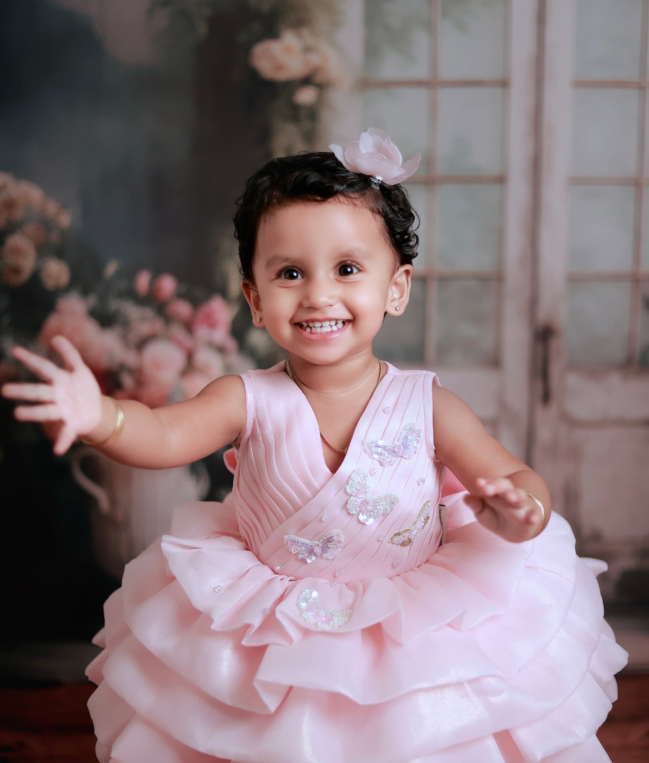 Close-up of the pink shimmer bodice showing the asymmetrical crossover design with butterfly motifs and crystals