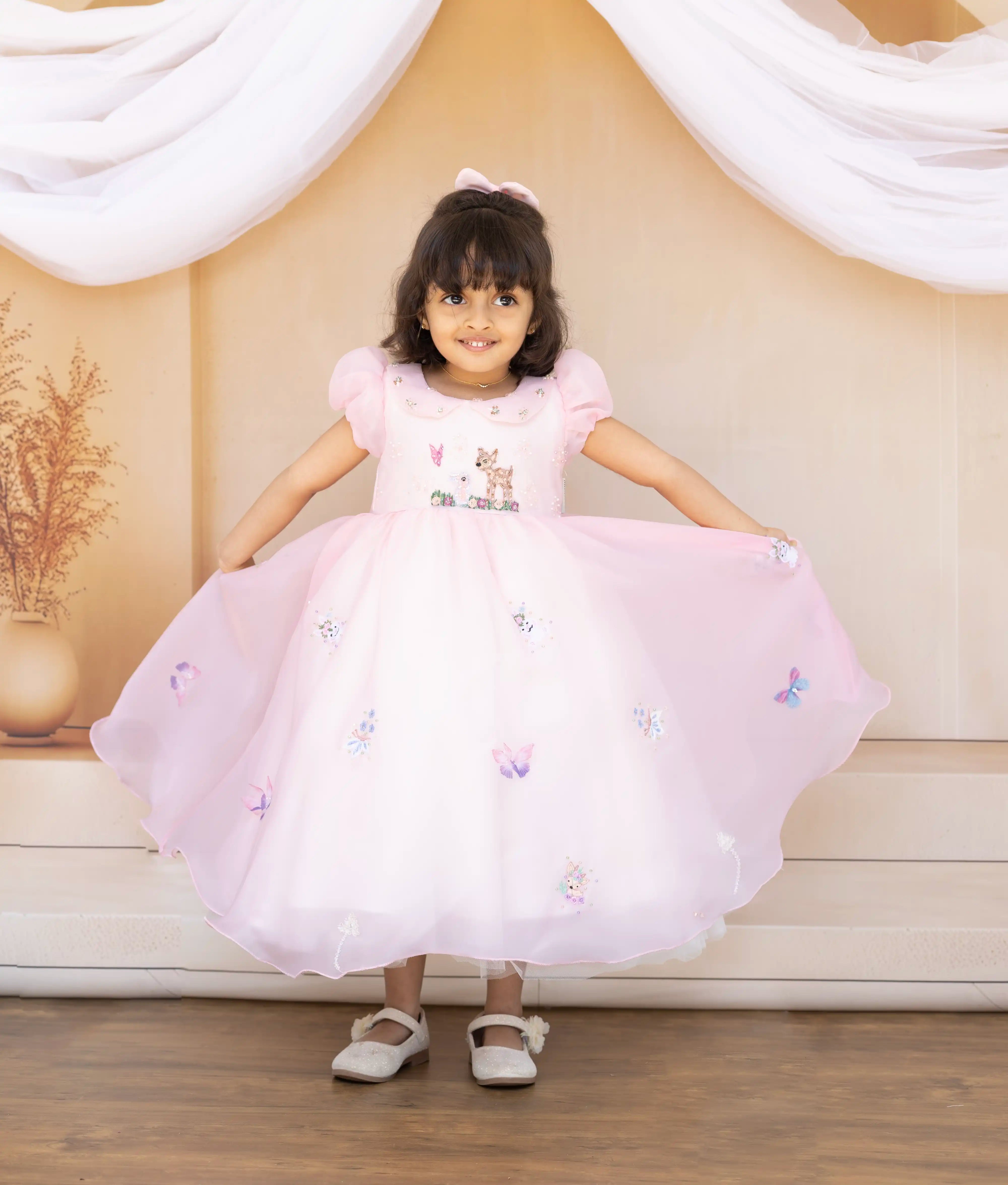 Close-up of the pink frock bodice showing the whimsical cat embroidery, Peter Pan collar, and puff sleeves