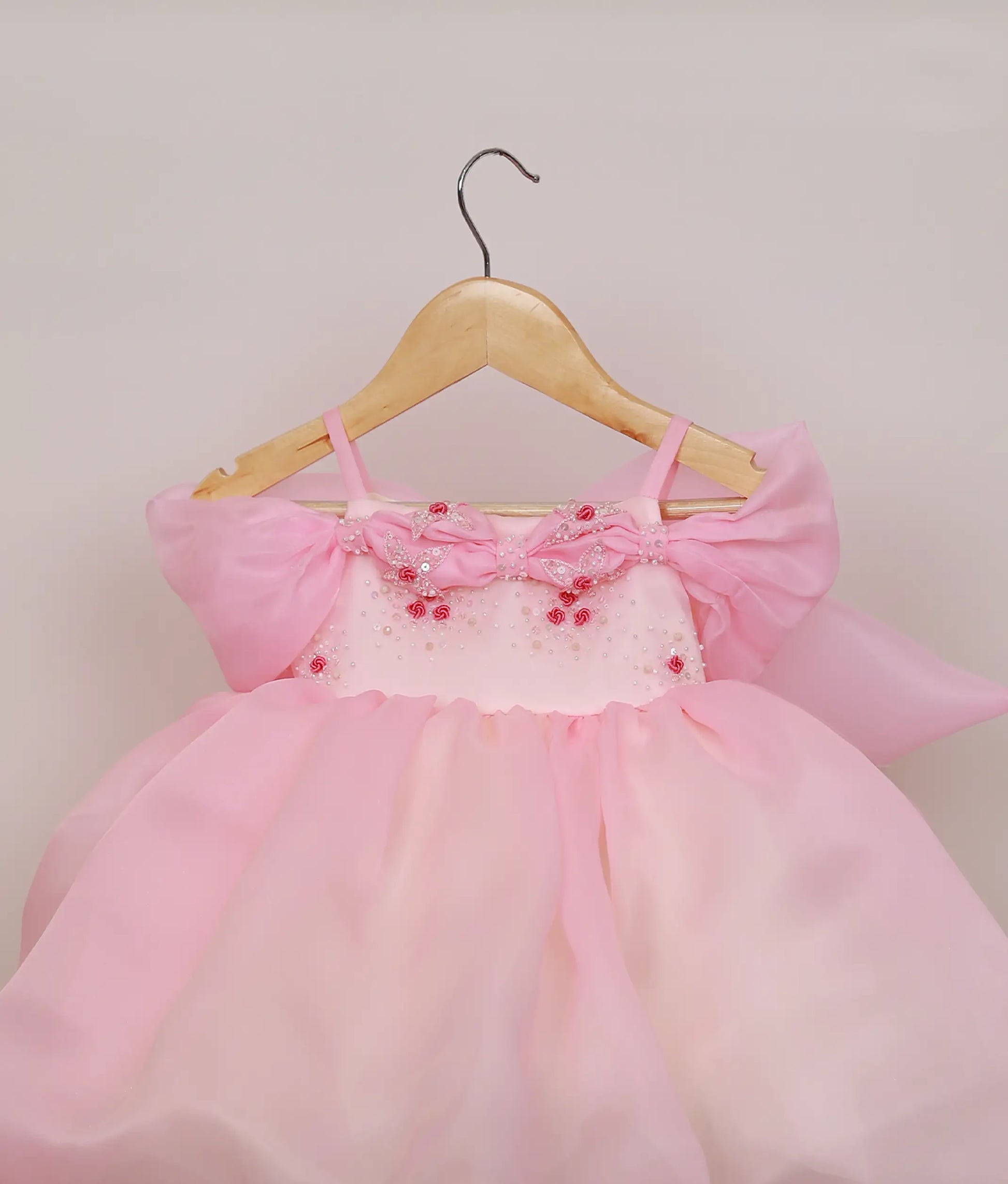 Close-up of the pink organza dress showing the detailed floral handwork and intricate beading on the bodice