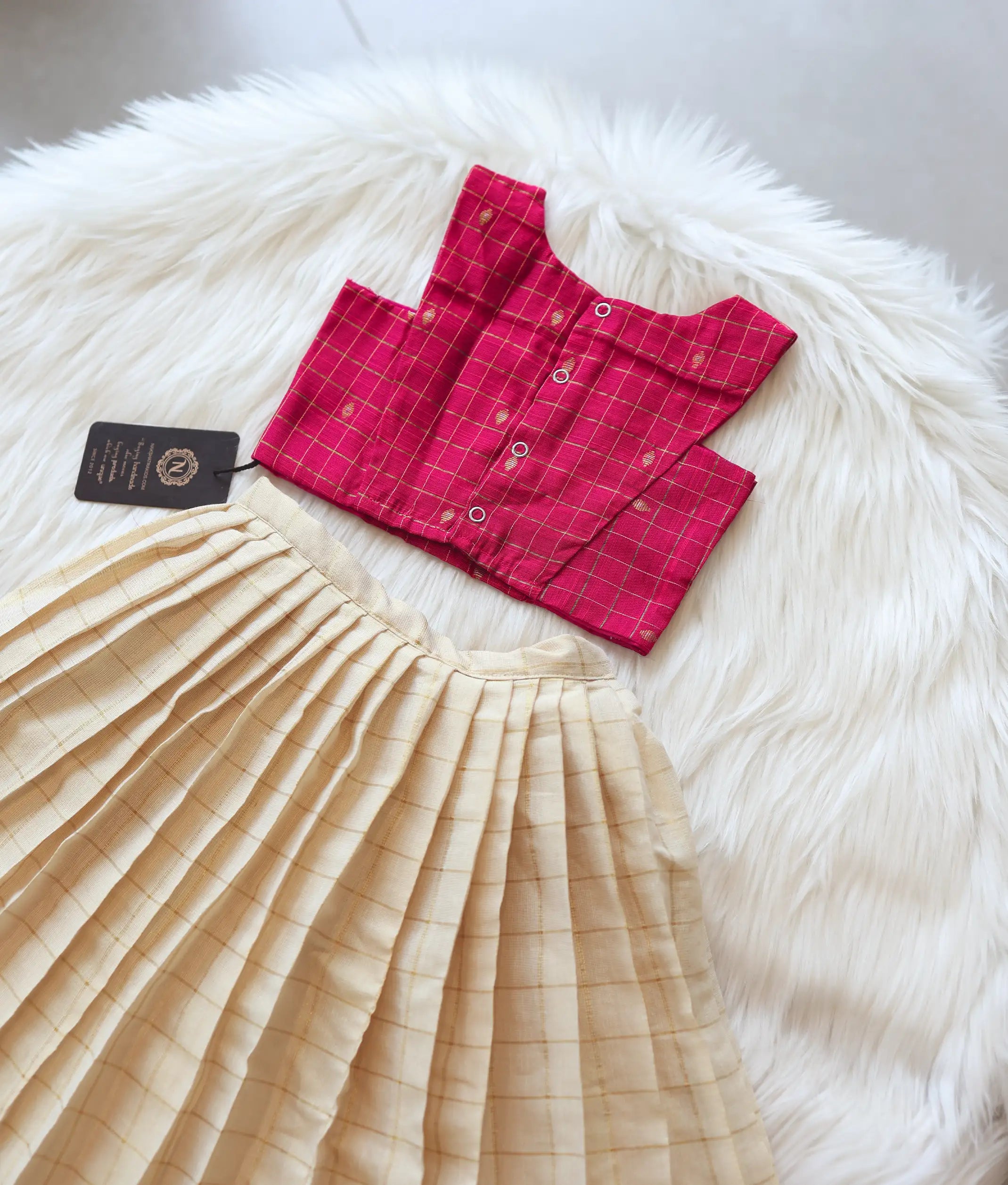 Back view of the pink check top showing the neat button closures and strap design.