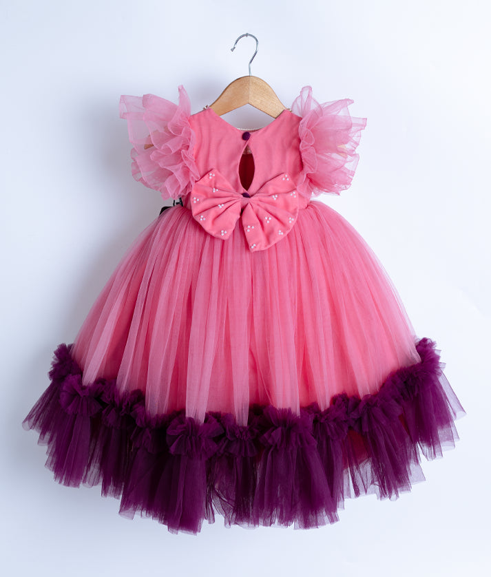 Back view of the pink gown highlighting the keyhole opening, show button, and large decorative bow.